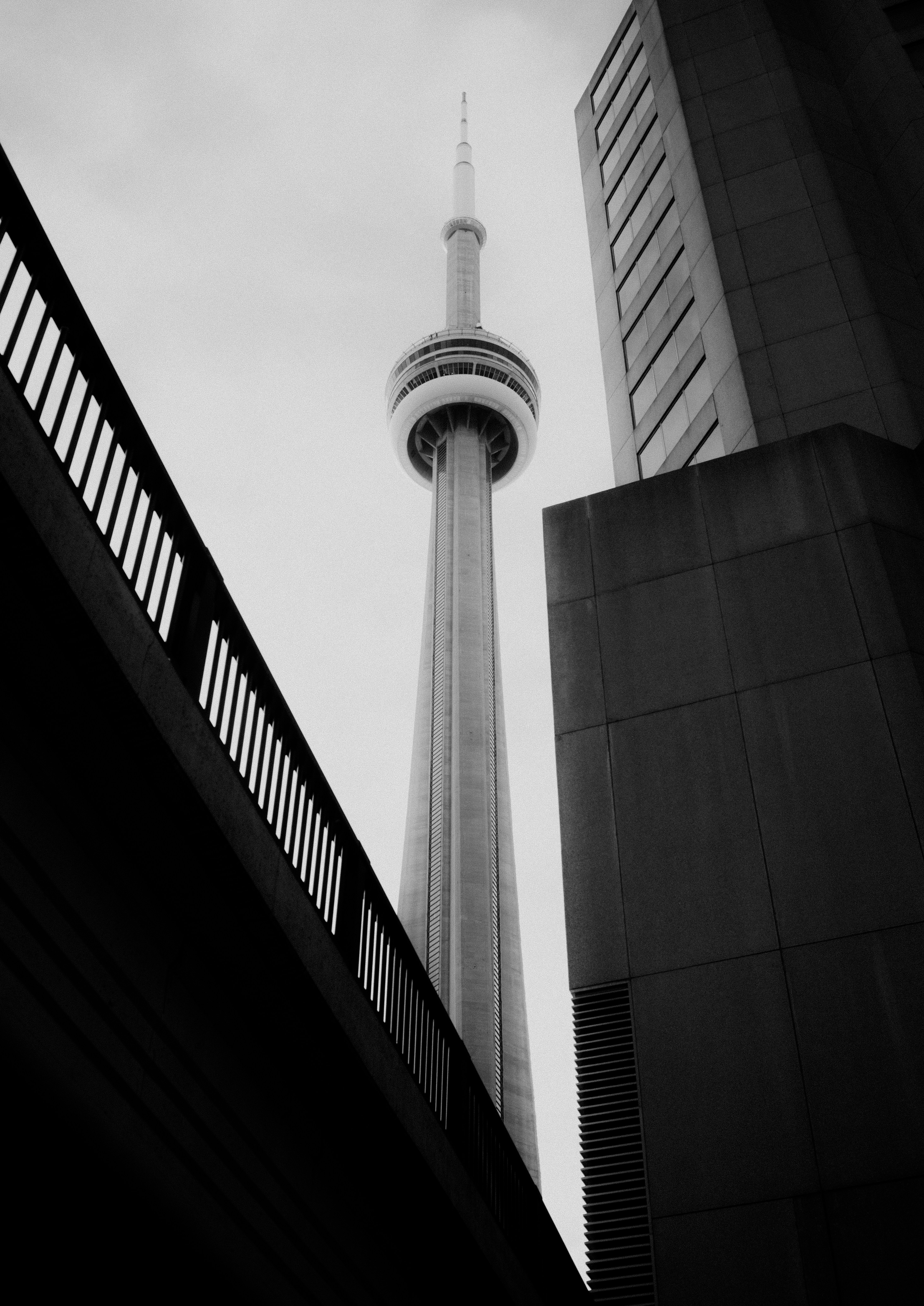 Photo of The cn tower stands tall between modern buildings. by Nik Iurev