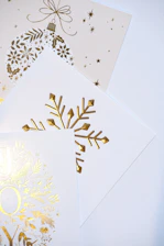 Golden christmas ornaments and snowflake designs on cards.