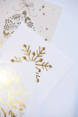 Golden christmas ornaments and snowflake designs on cards.