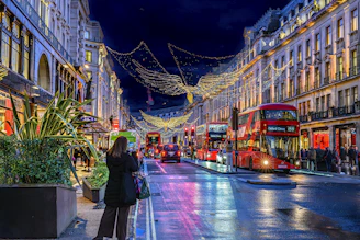 A london street decorated with christmas lights at night.