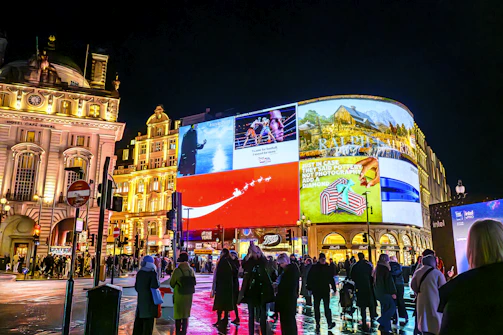 Vibrant cityscape at night with illuminated billboards.