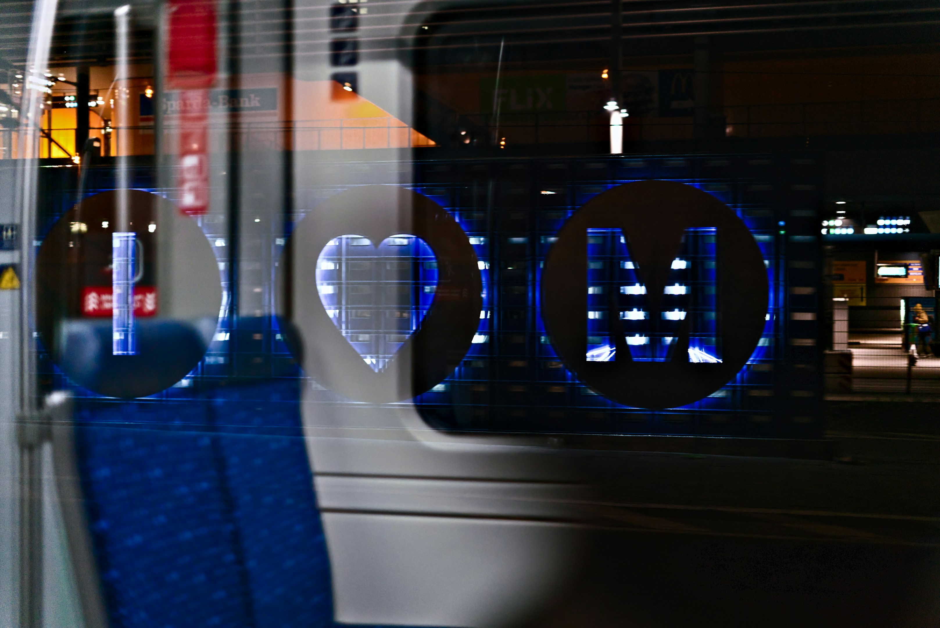 Heart and m symbol reflected on train window