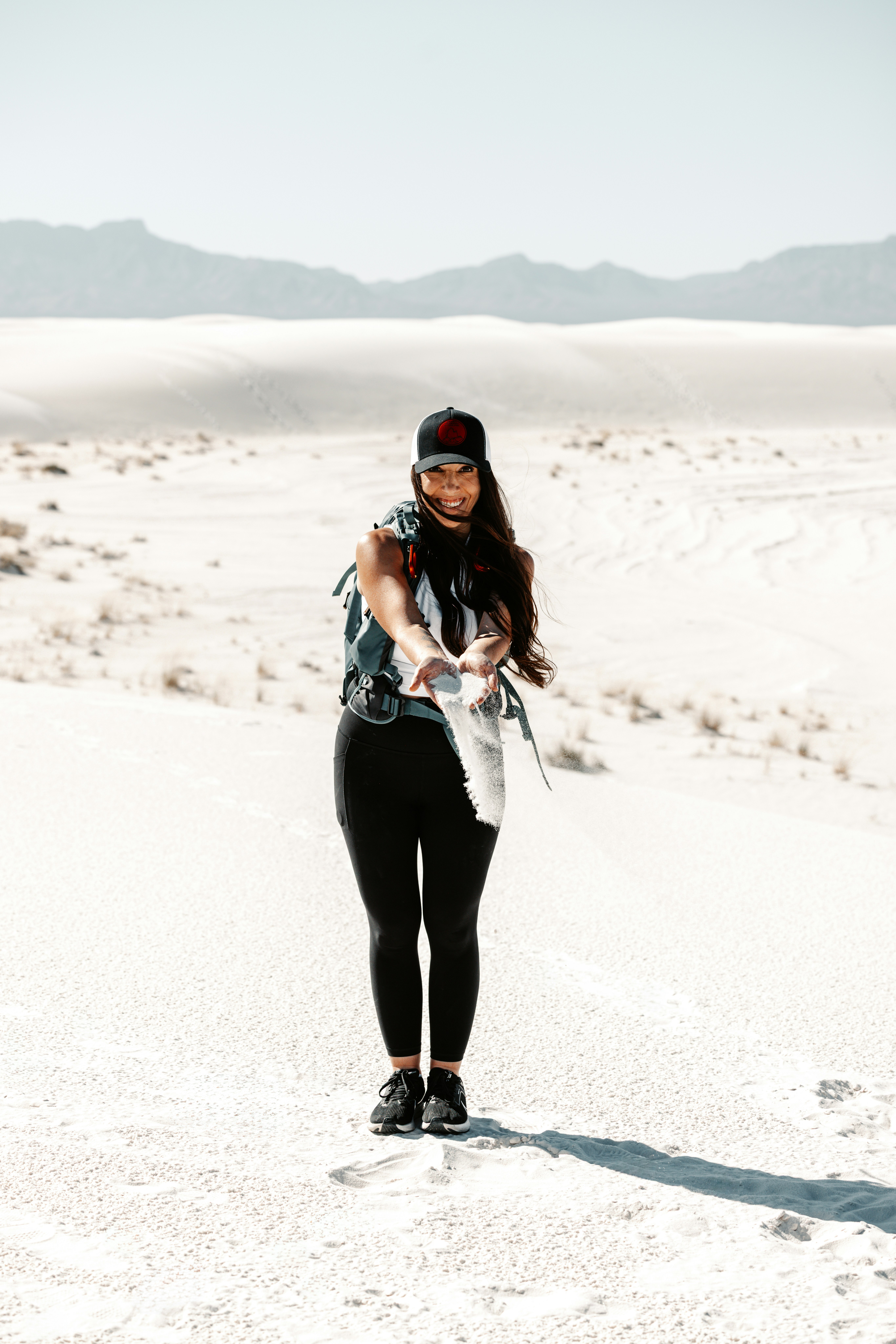 Woman standing in a vast white desert landscape.