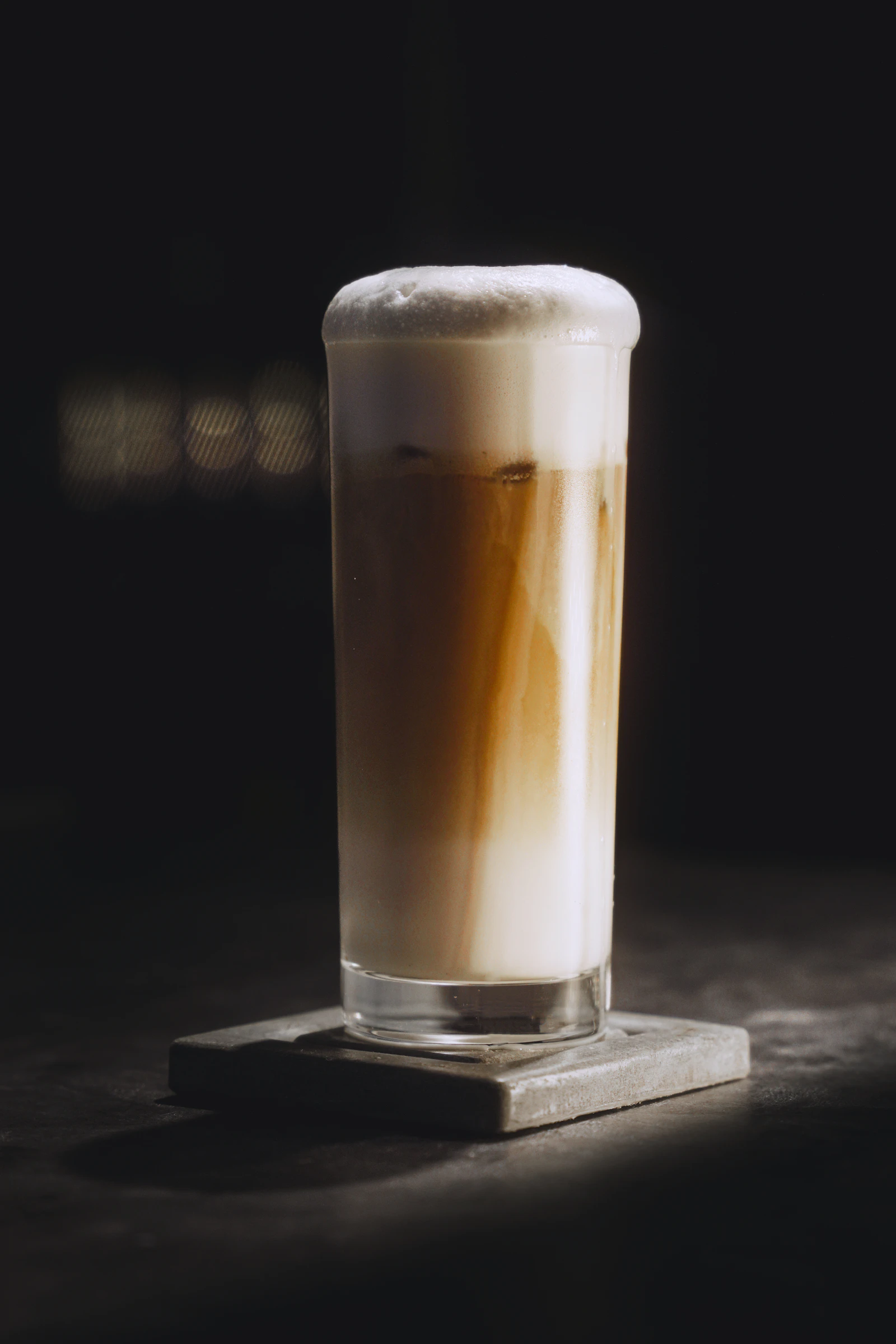 Tall glass of iced coffee with a pale foam layer