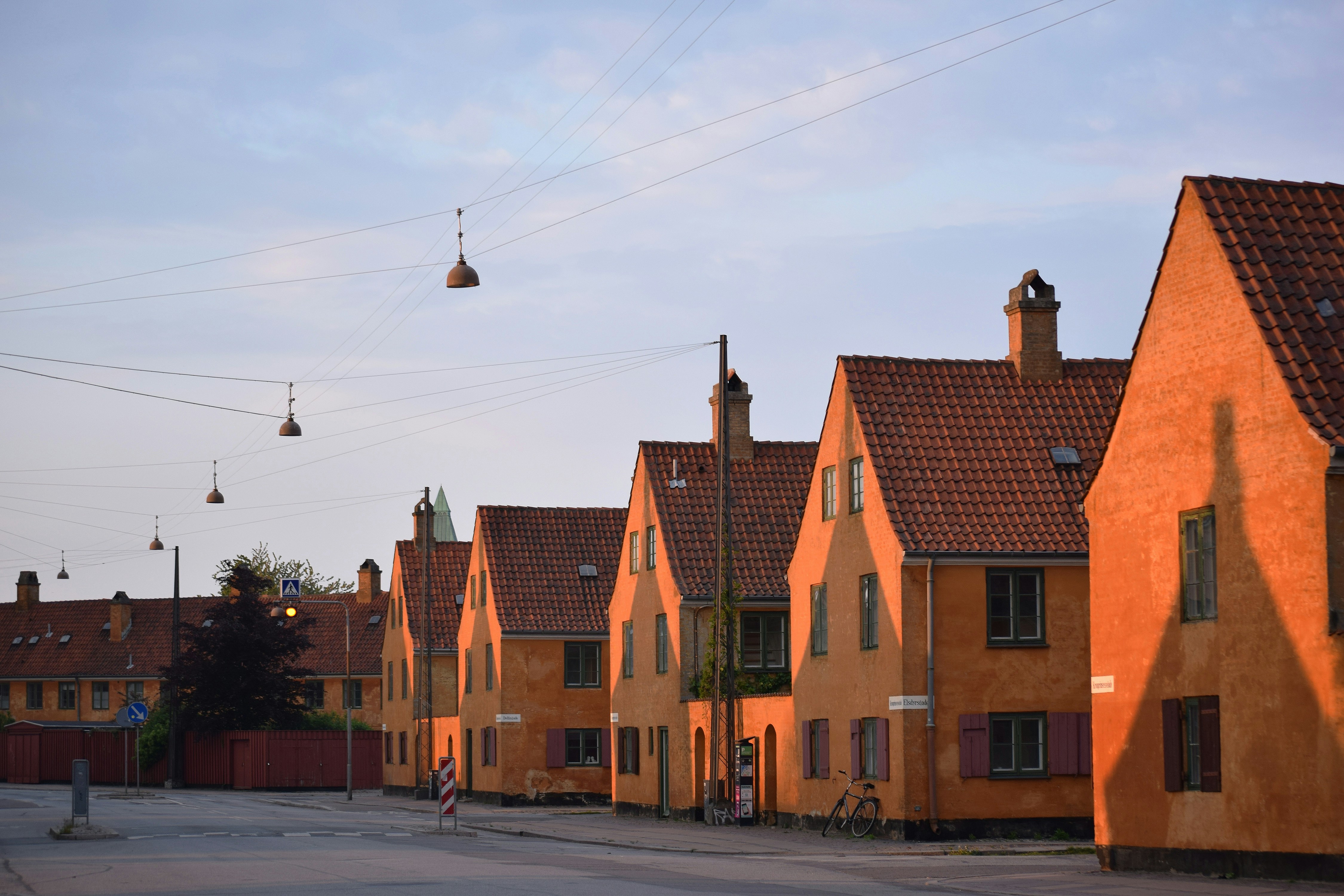Row of orange houses with red tile roofs.