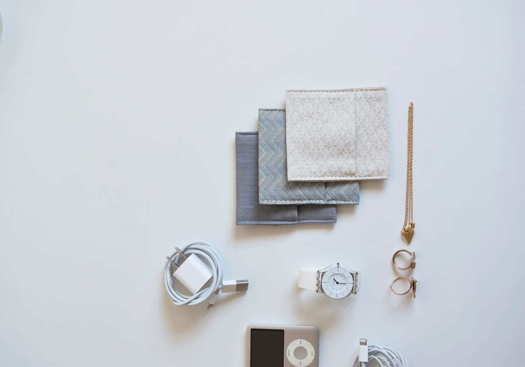 Travel pouches, charging cables and small electronic accessories arranged for organized packing