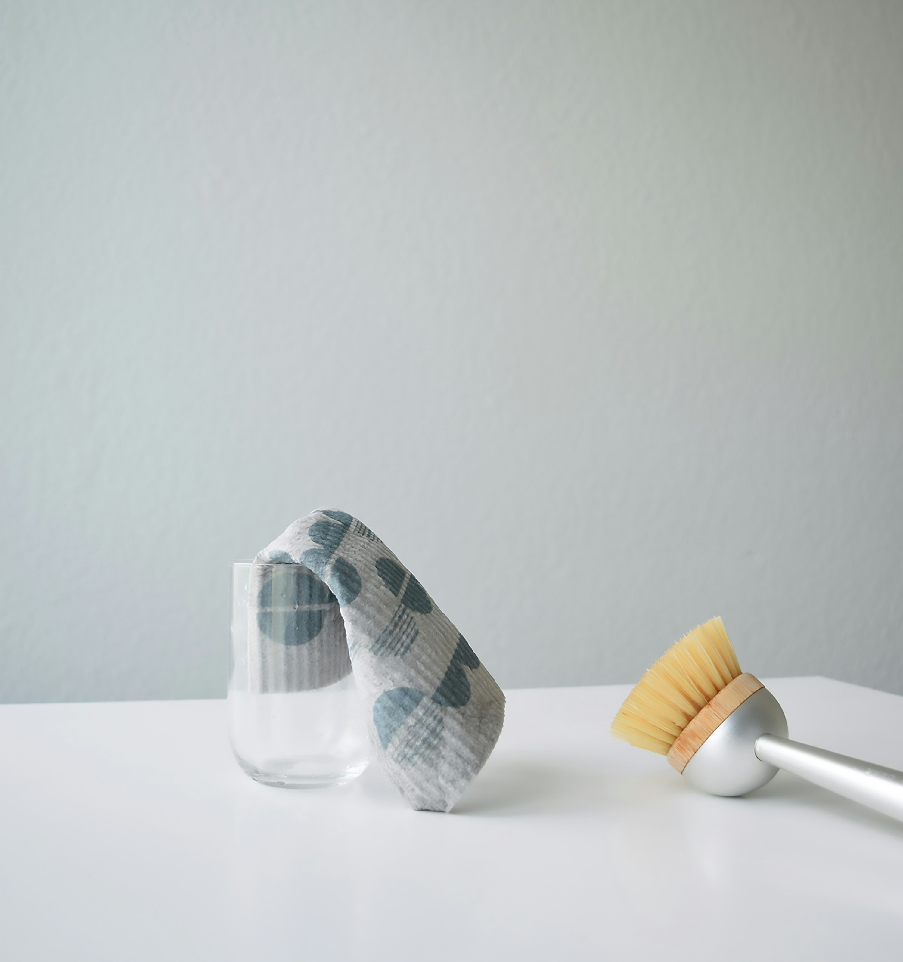 A glass with a cloth and a brush