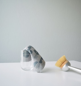 A glass with a cloth and a brush