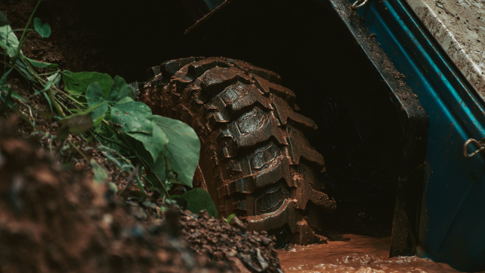 Heavily treaded off-road tire covered in mud