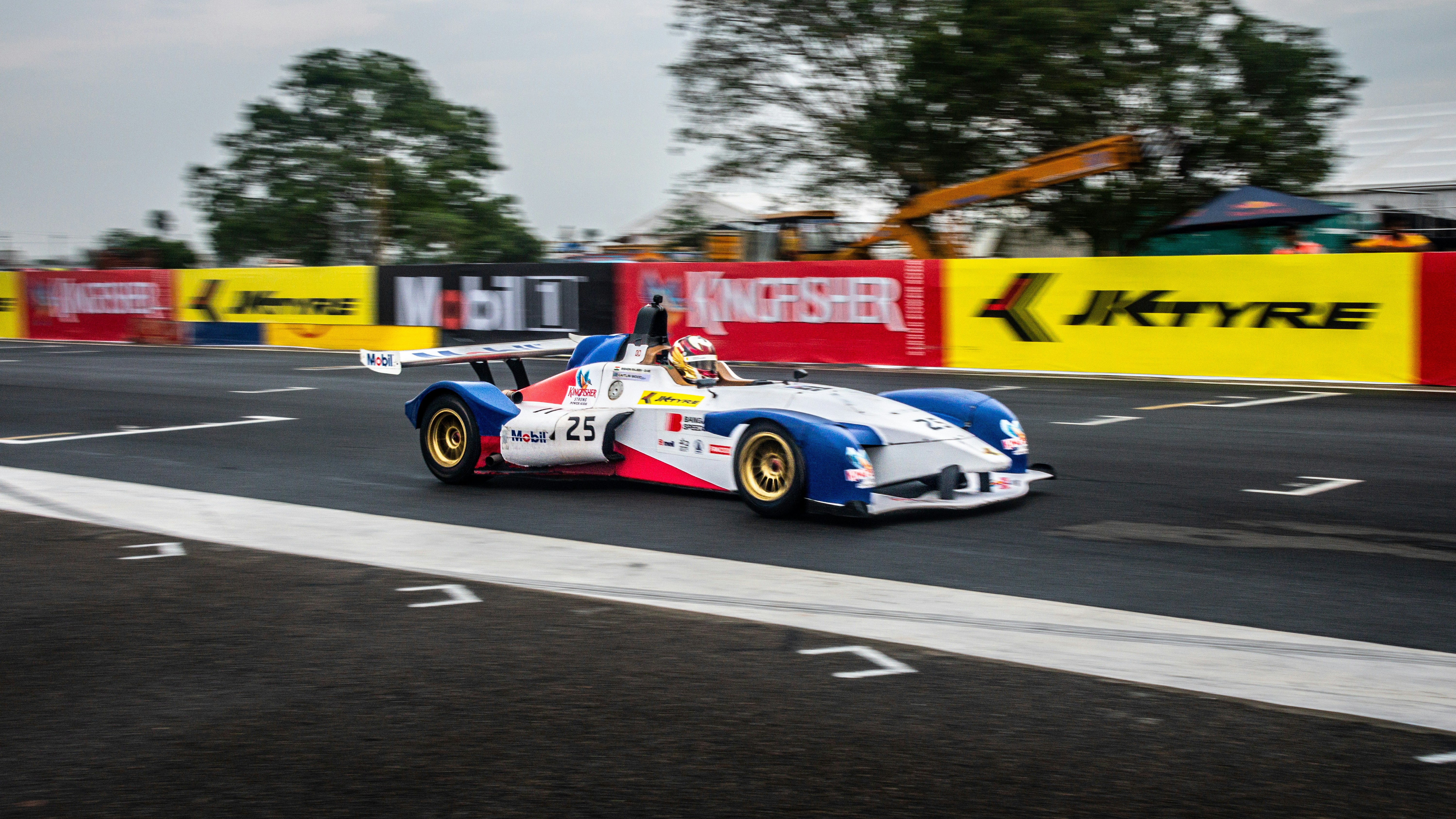 Voiture de course filant sur une piste avec des banderoles.