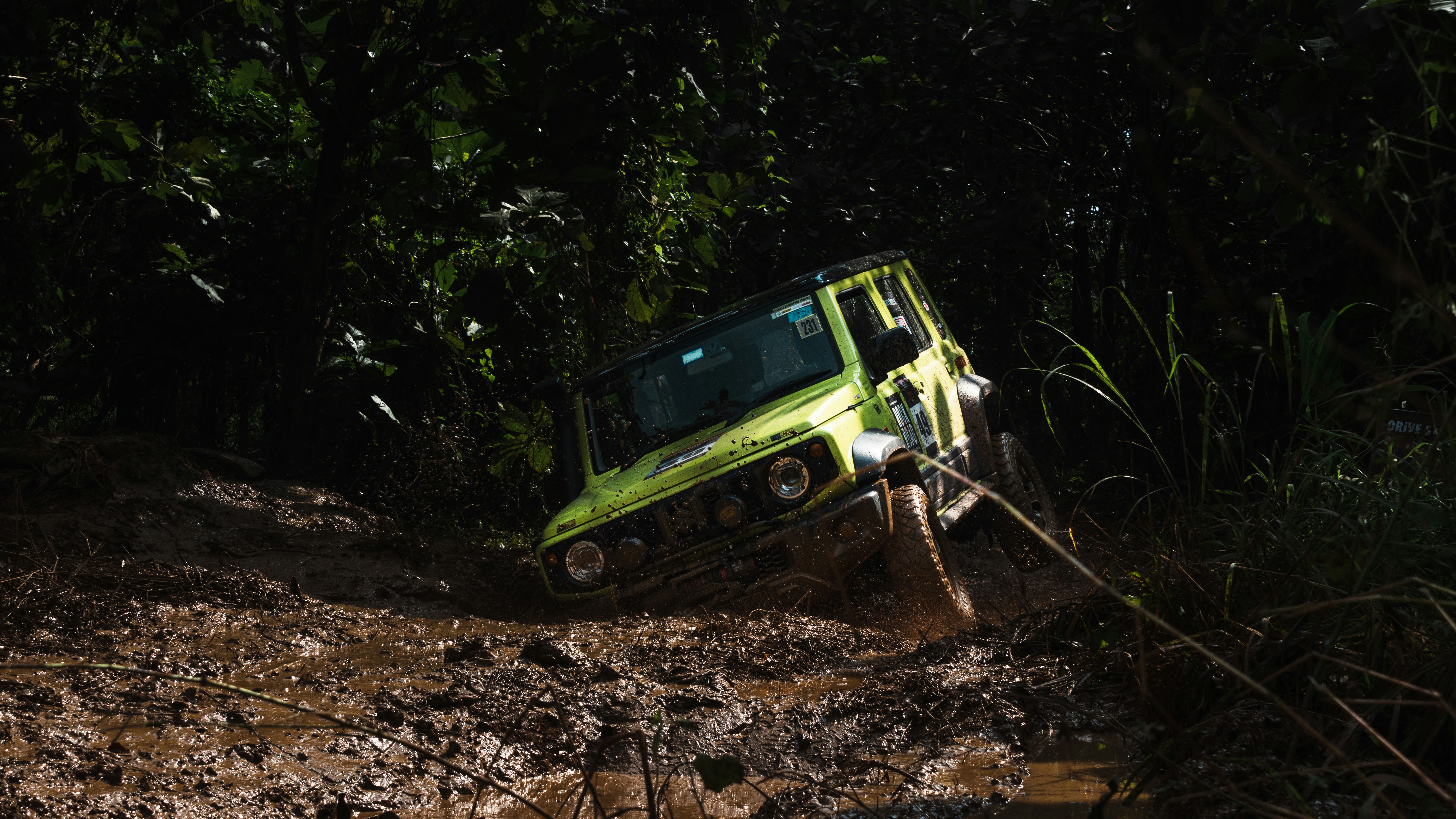 Un véhicule tout-terrain vert citron coincé dans la boue