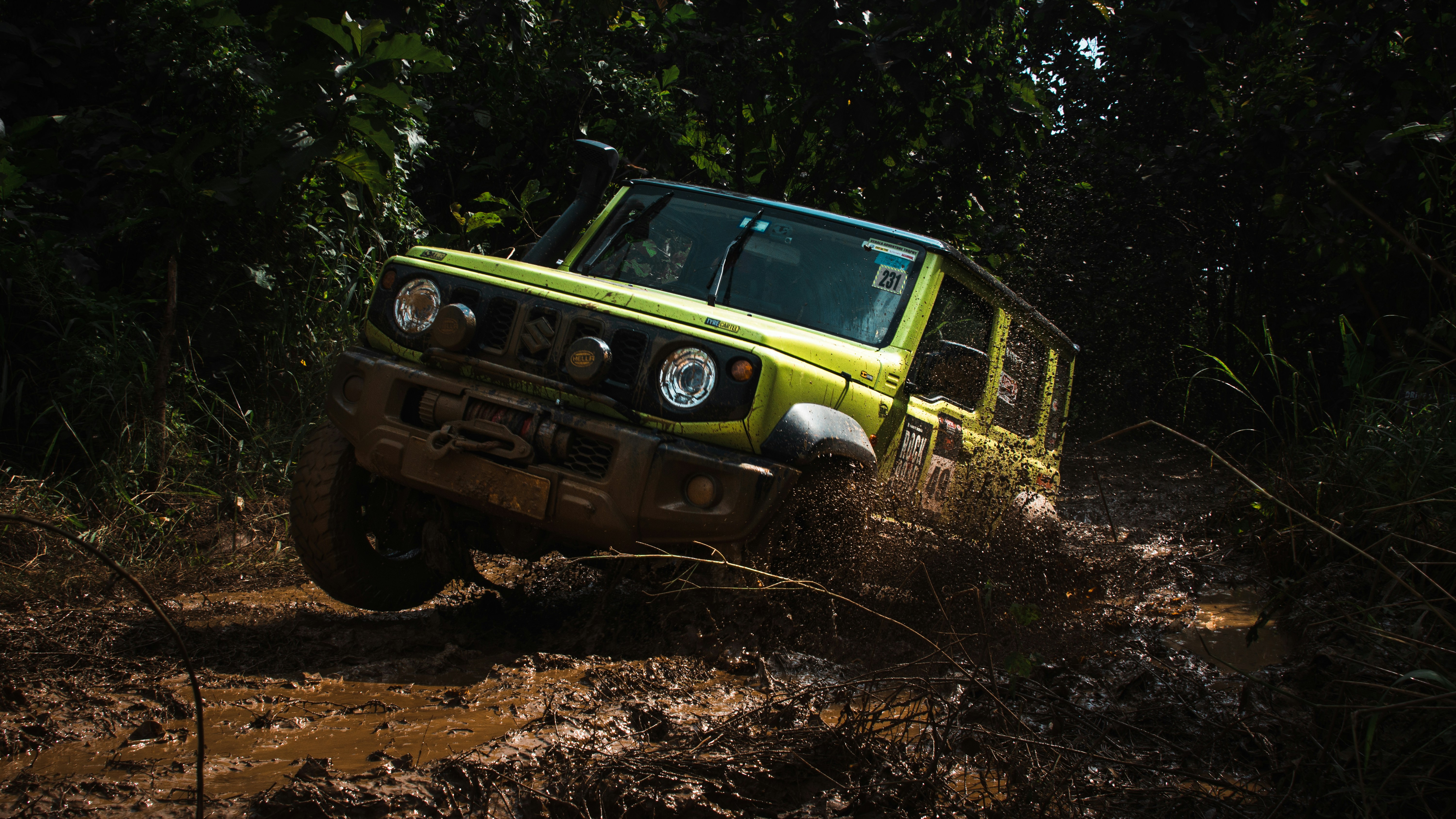 Jeep jaune traversant un sentier forestier boueux