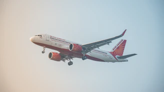 A red and white airplane flying in the sky