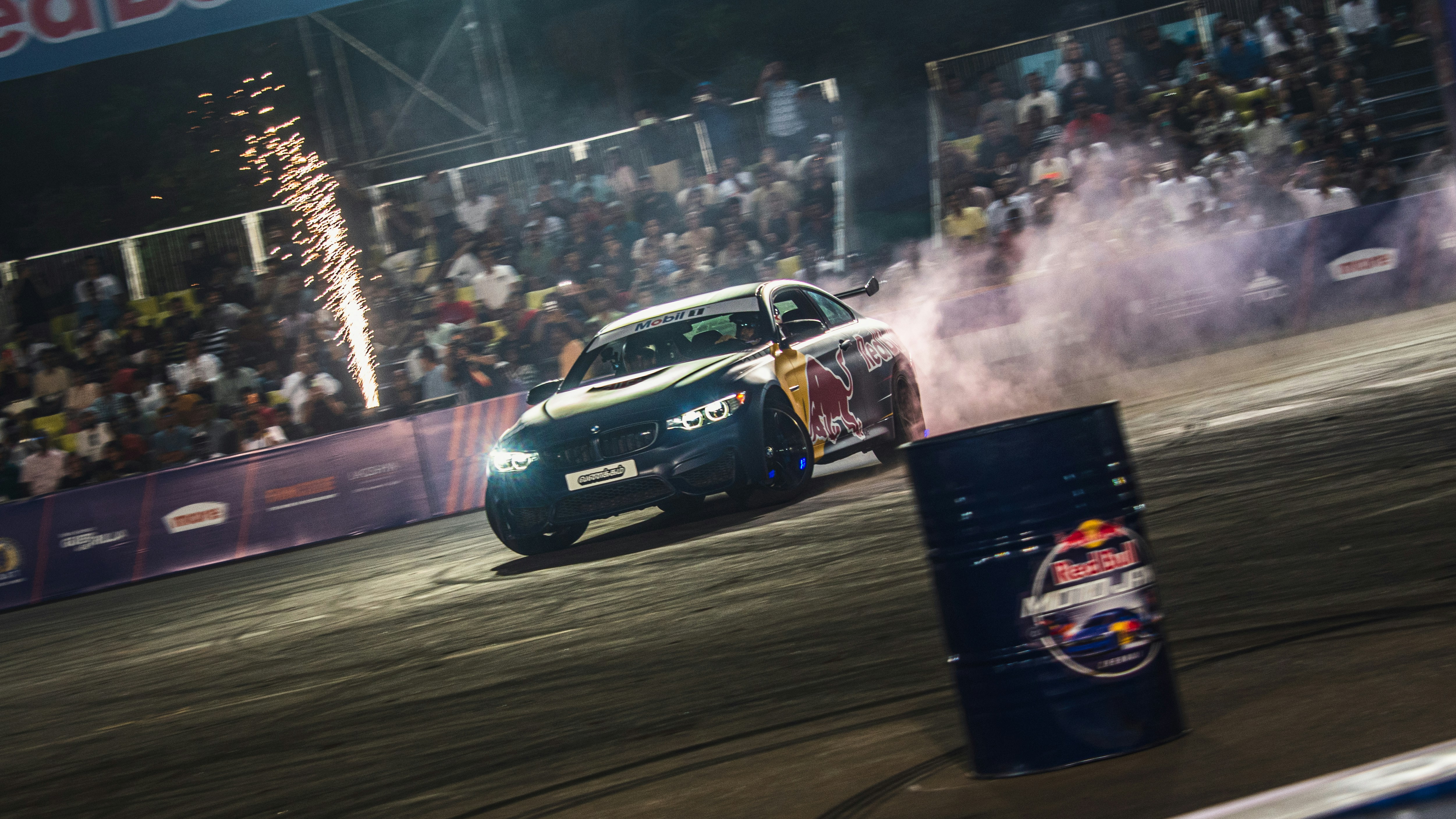 Voiture de drift avec fumée et feux d’artifice lors d’un événement nocturne