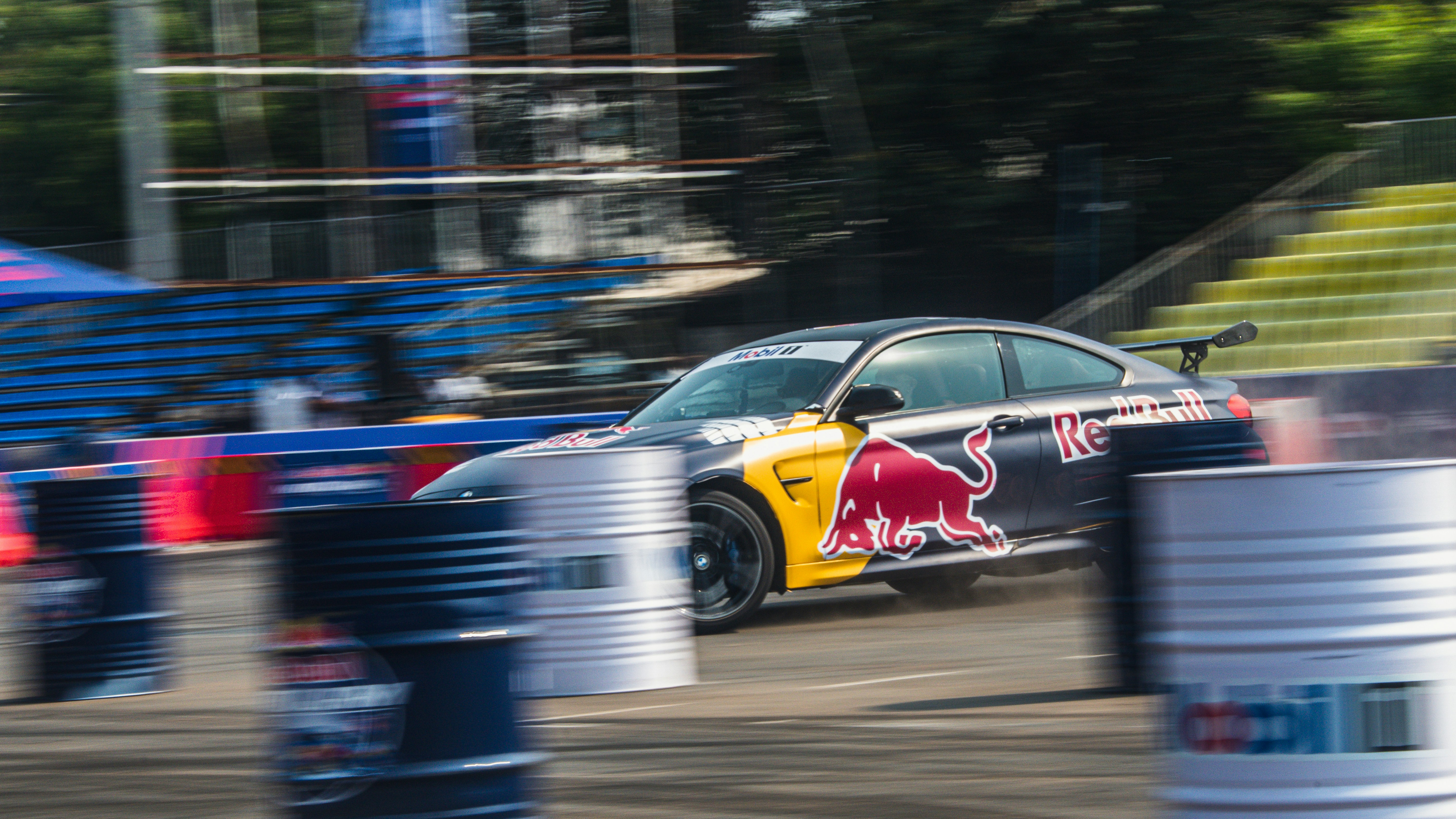 Voiture de course avec le logo Red Bull qui dérape autour des tonneaux