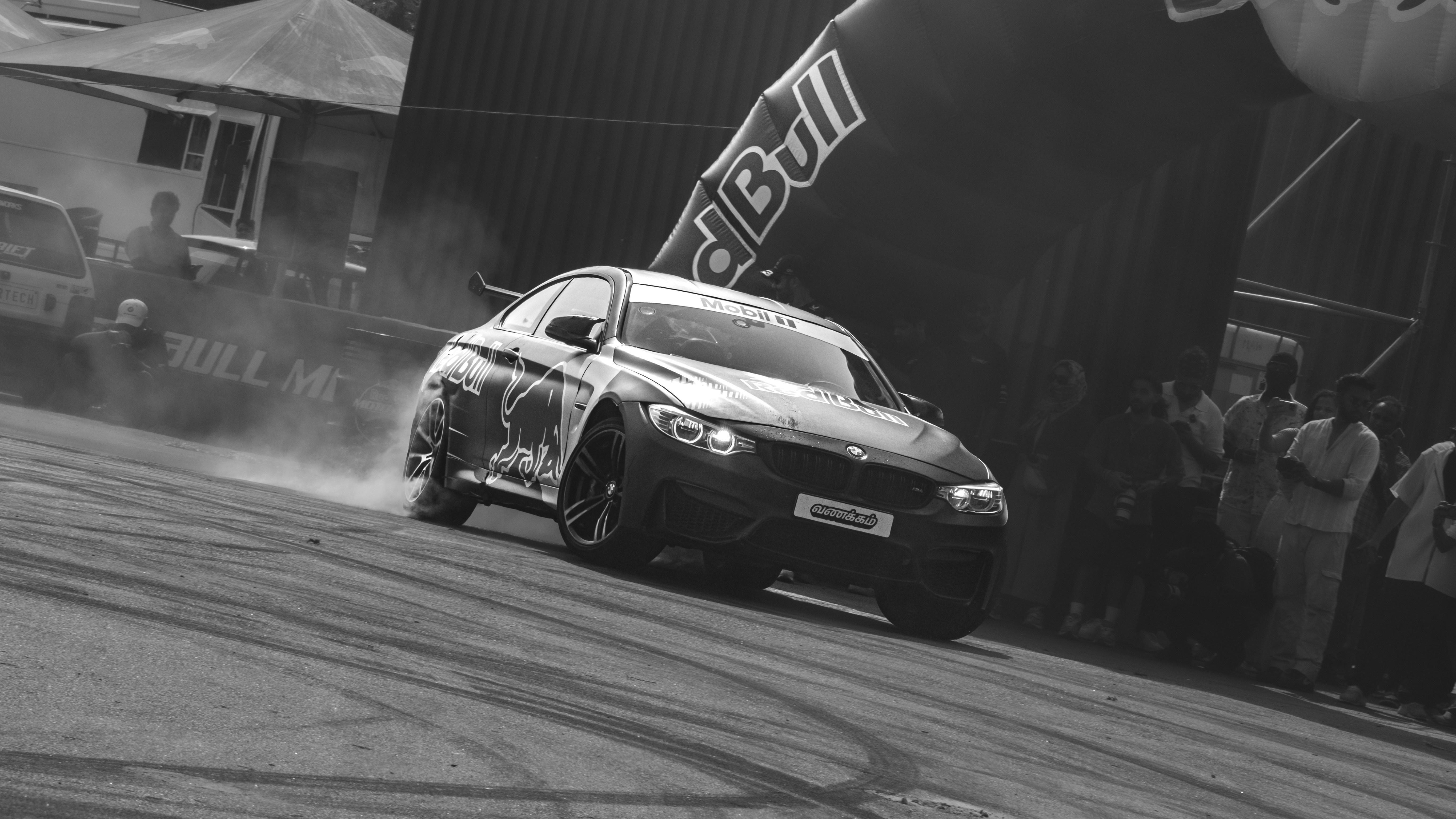 Une voiture de course dérape dans un virage avec de la fumée.