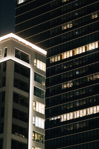 Modern buildings with illuminated windows at night.