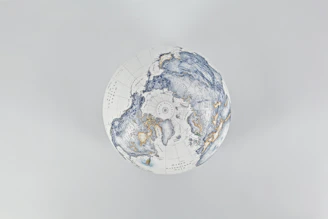 A stylized globe with intricate blue and gold patterns.