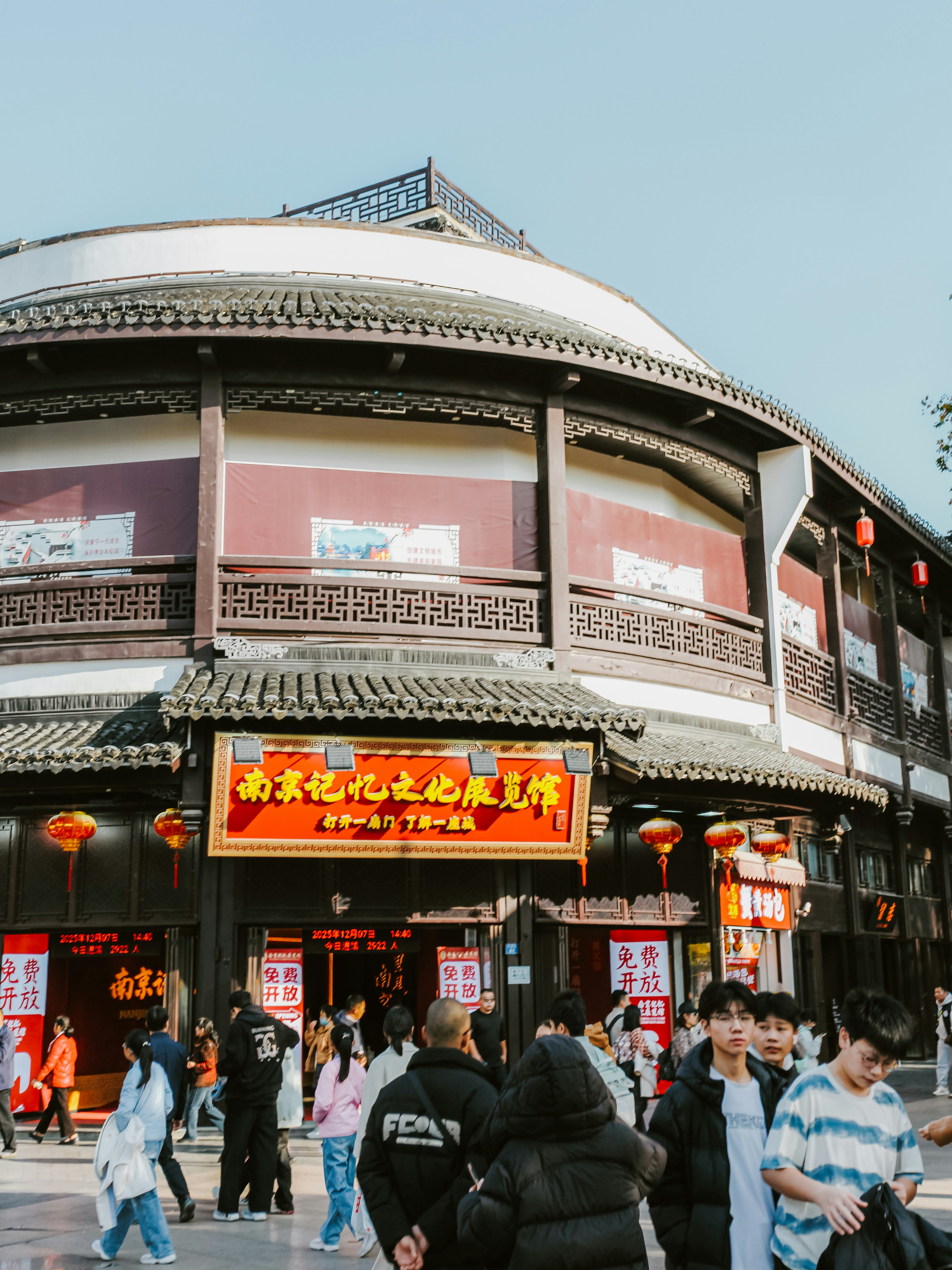 People walk in front of a traditional chinese building.