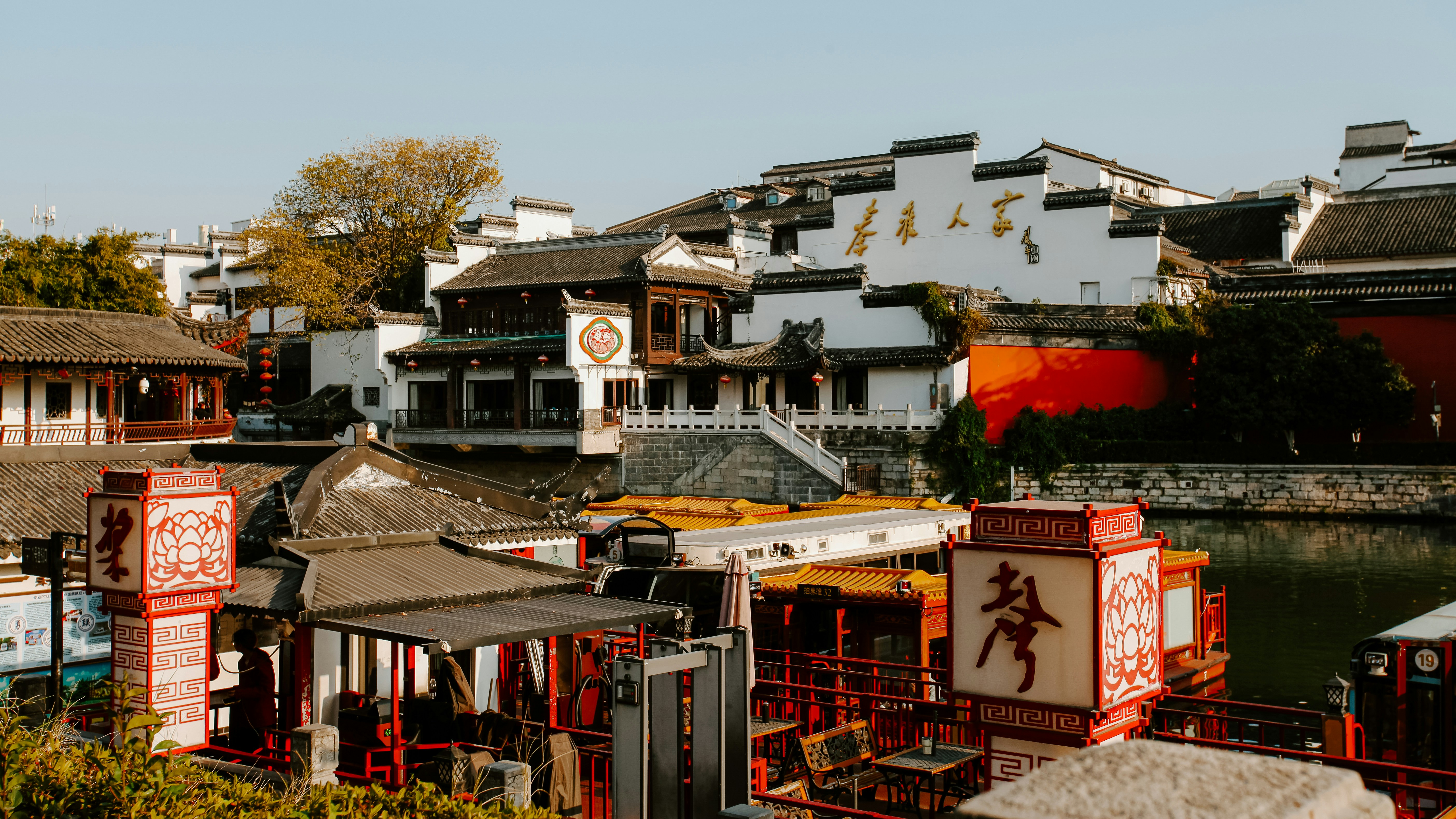 Traditional chinese buildings line a canal with boats.
