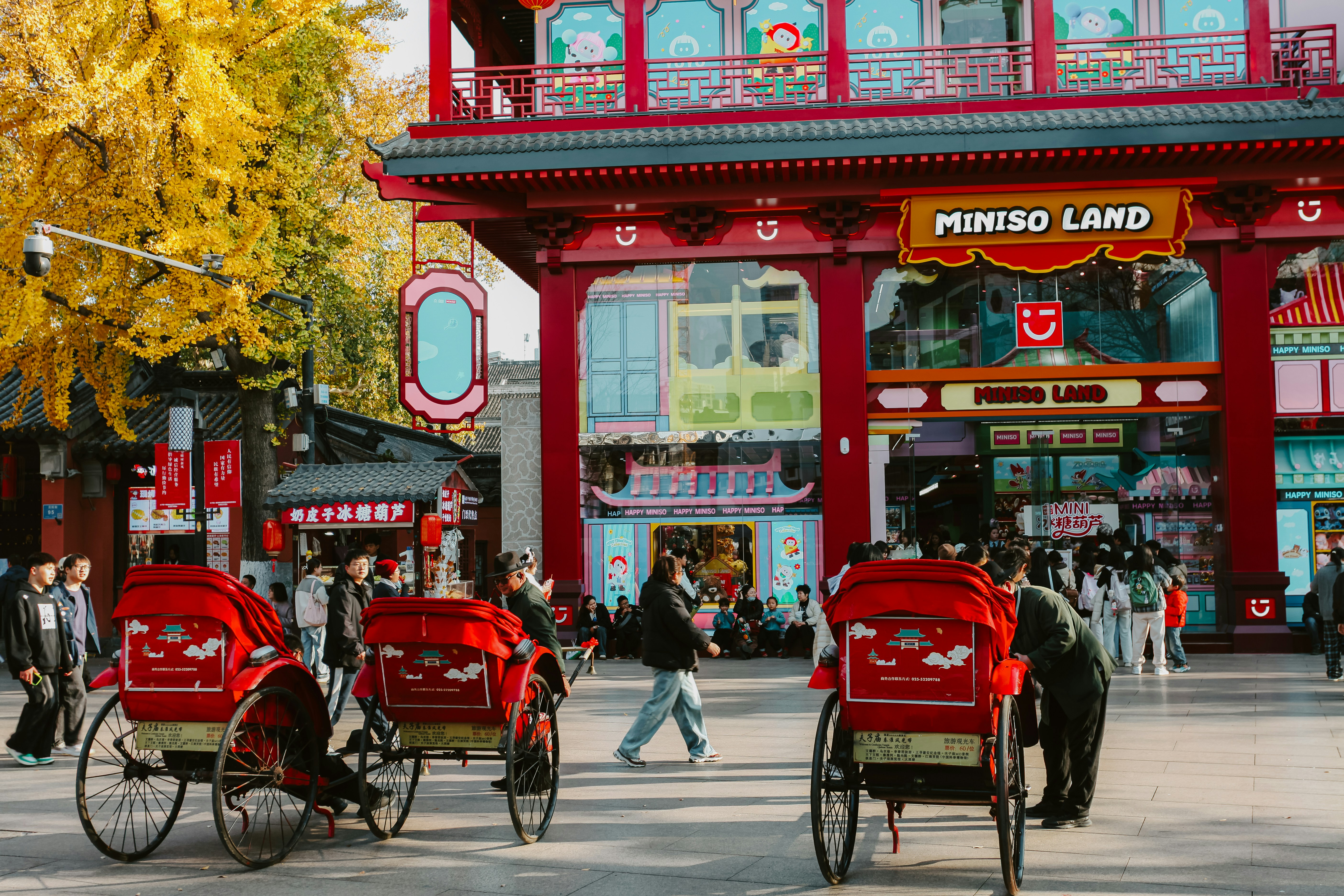 Rickshaws in front of a colorful asian marketplace
