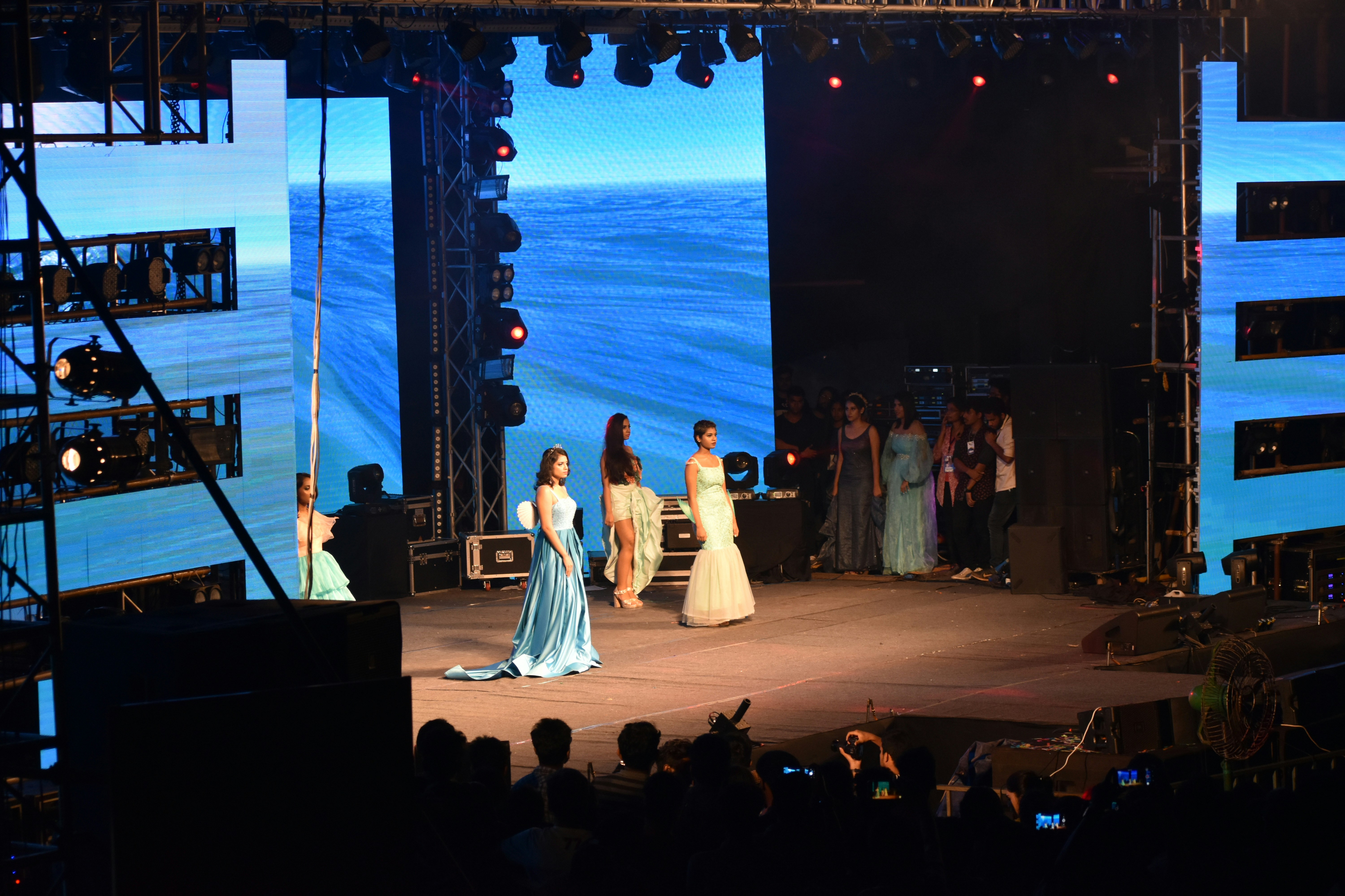 Mulheres no palco com pano de fundo oceânico