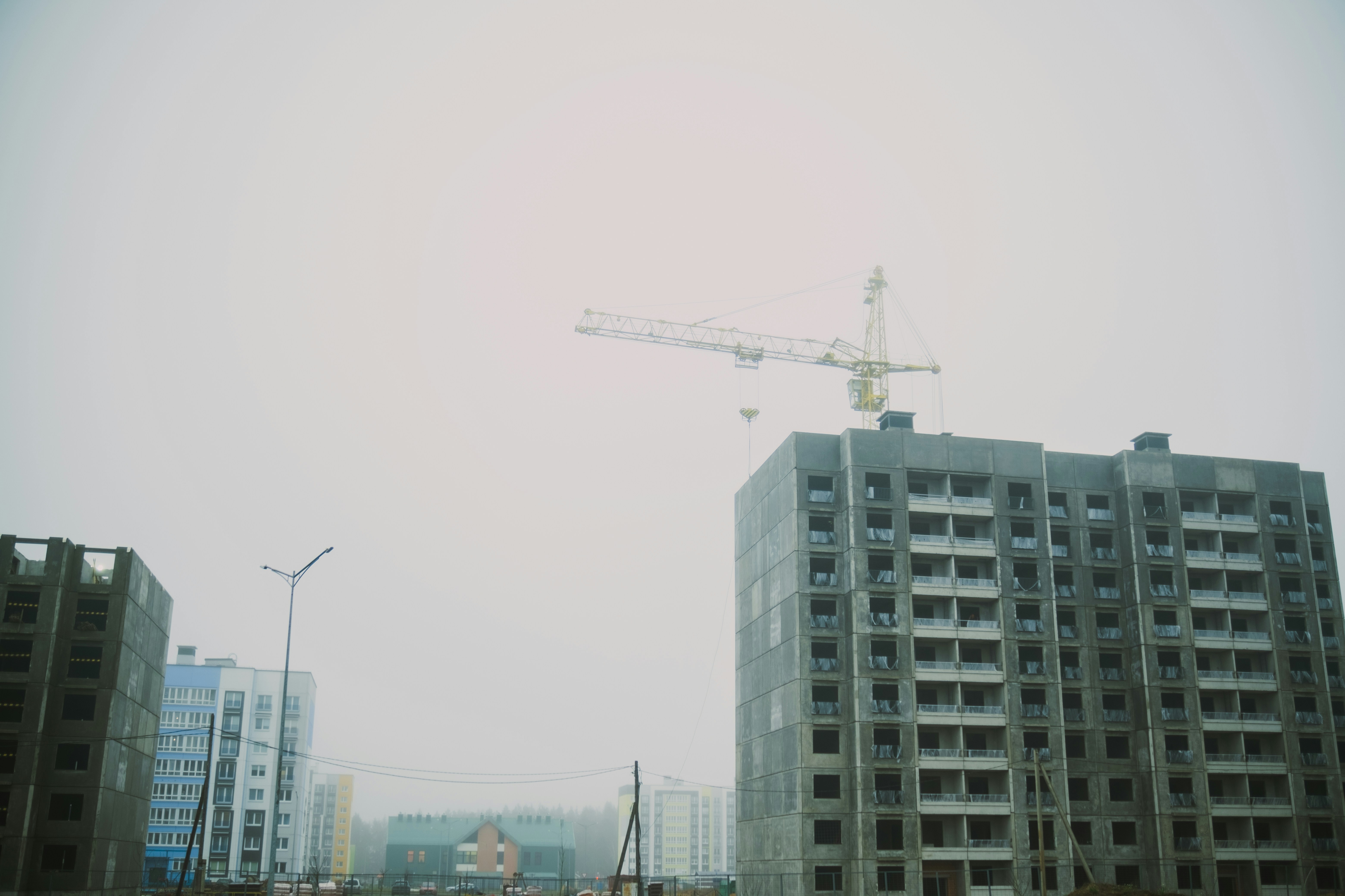 Construction crane above unfinished apartment buildings.