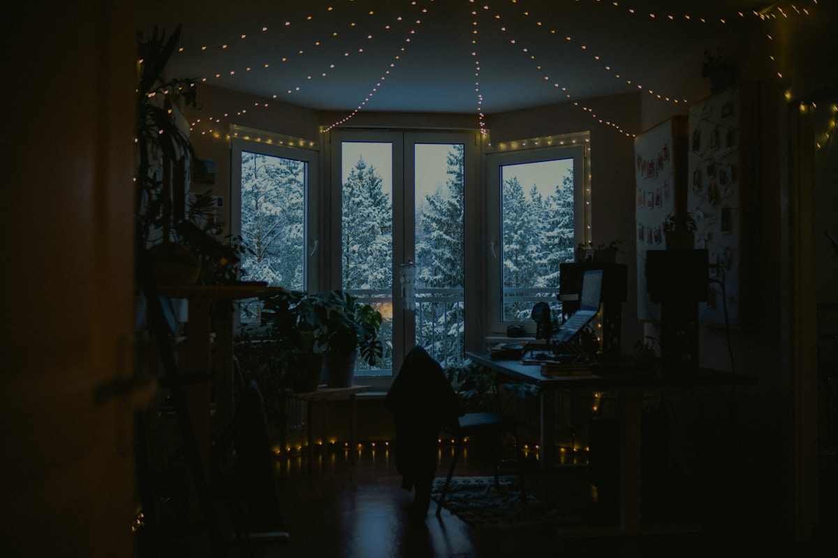 Cozy room with fairy lights and snowy window view.
