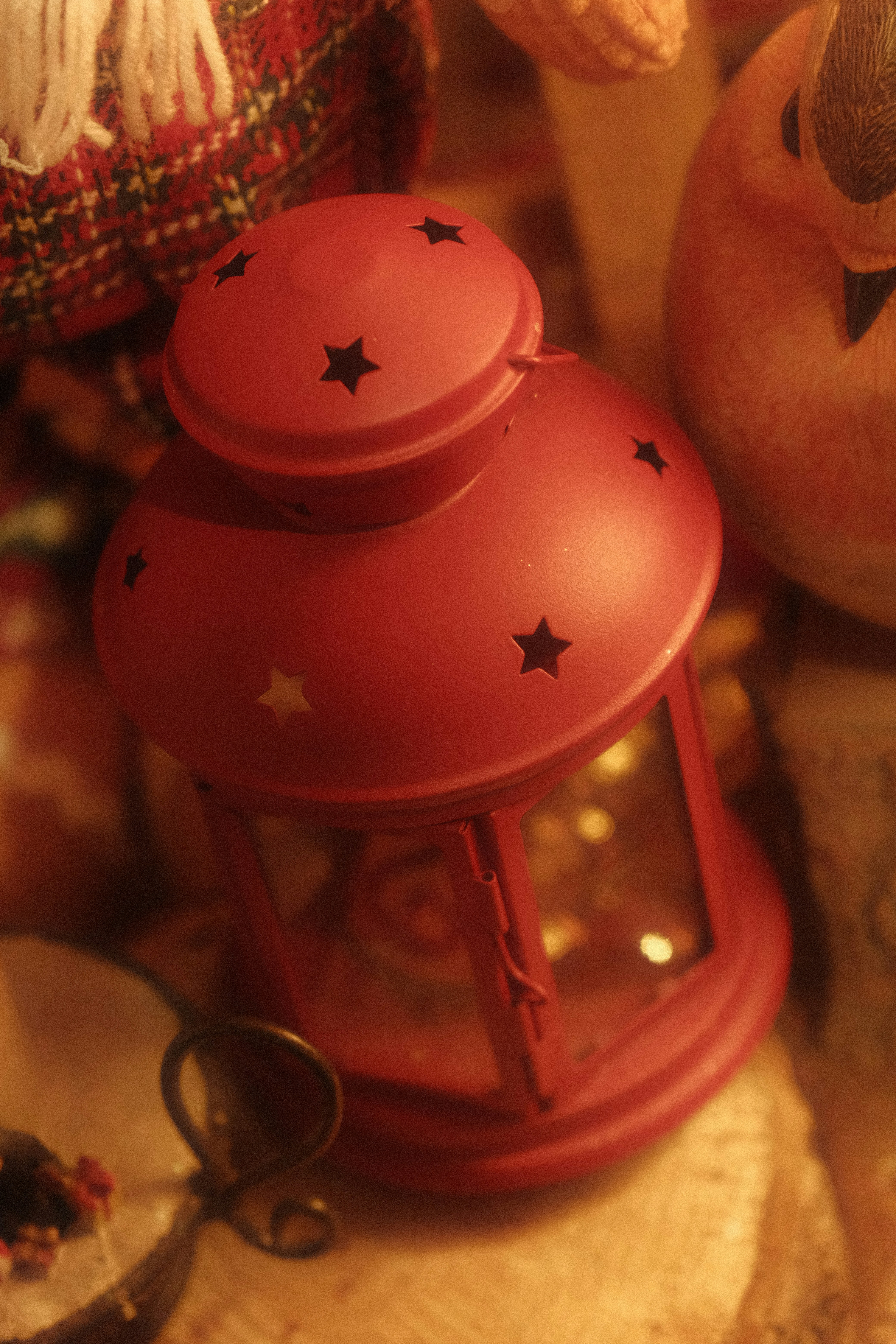 A red lantern with star cutouts sits on a surface.