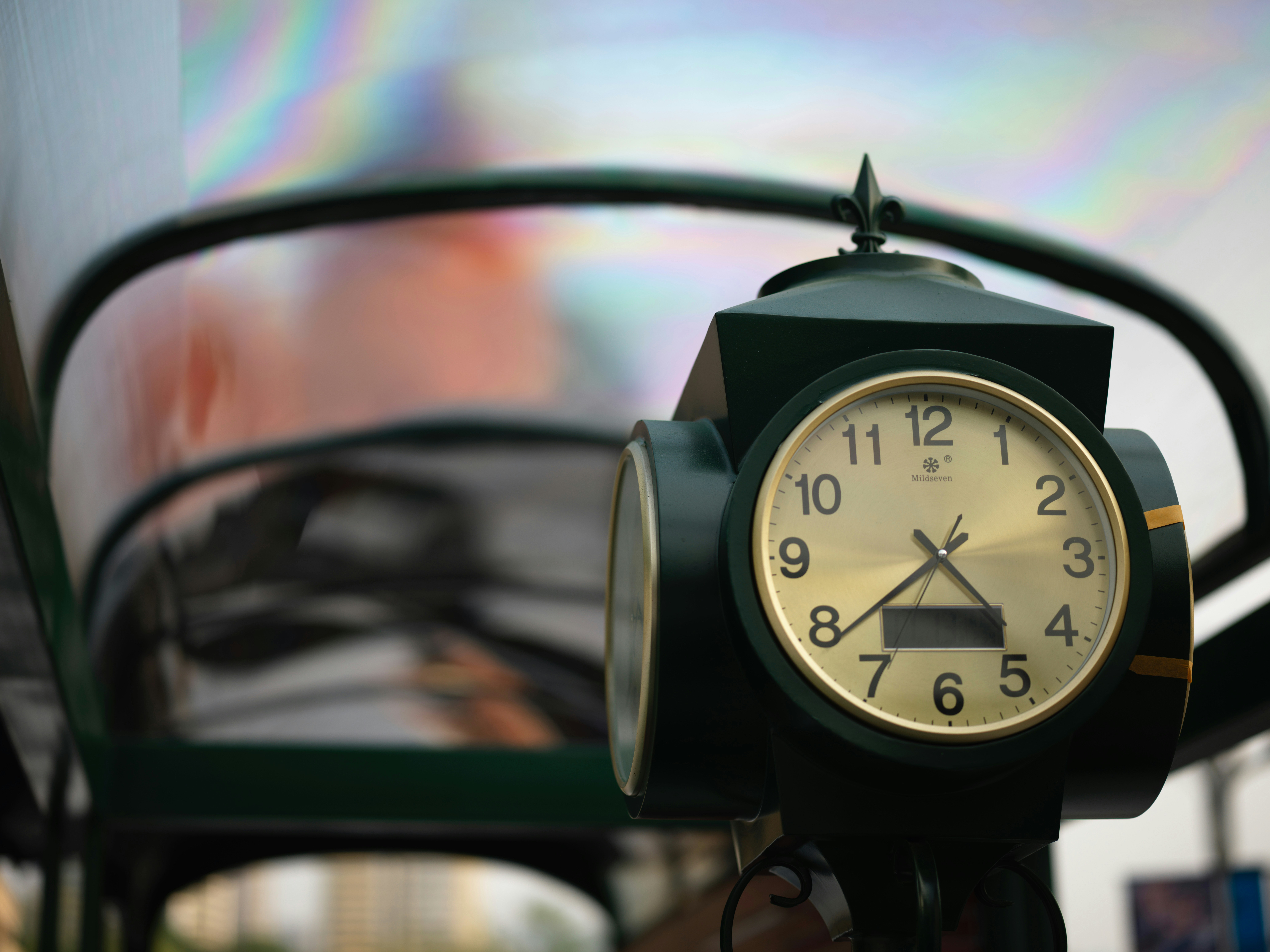 Close-up of a dark green clock with a gold face.