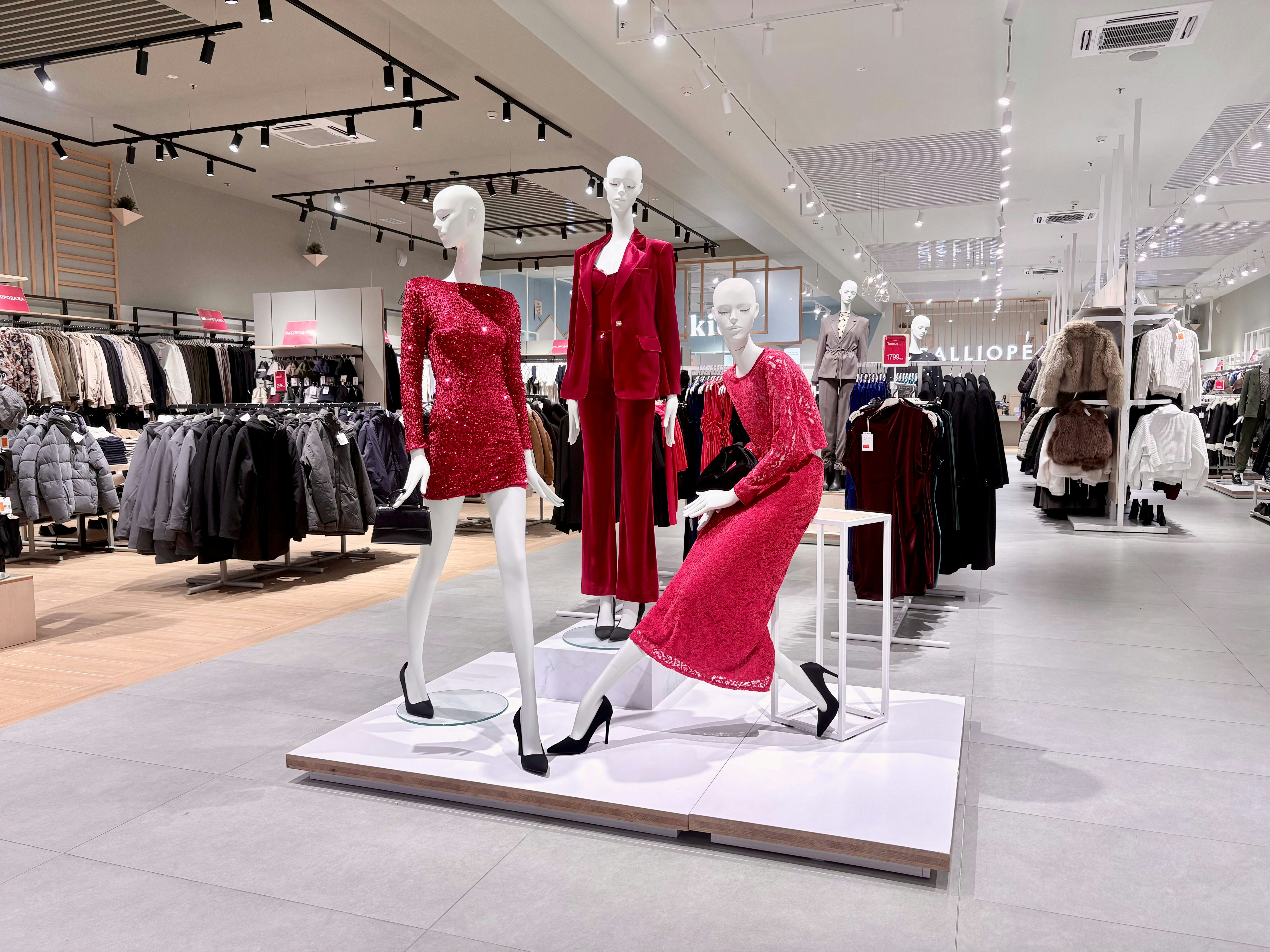 Mannequins in stylish red outfits displayed in store.