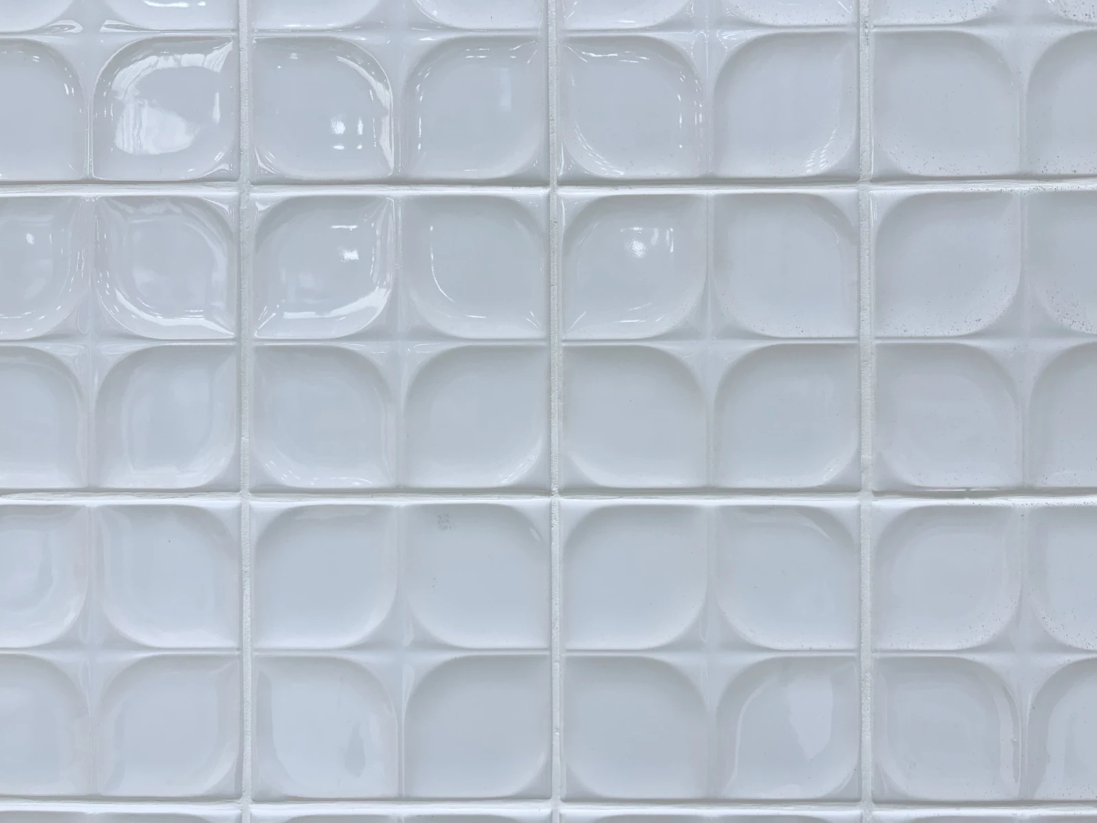 A grid of white textured backsplash tiles