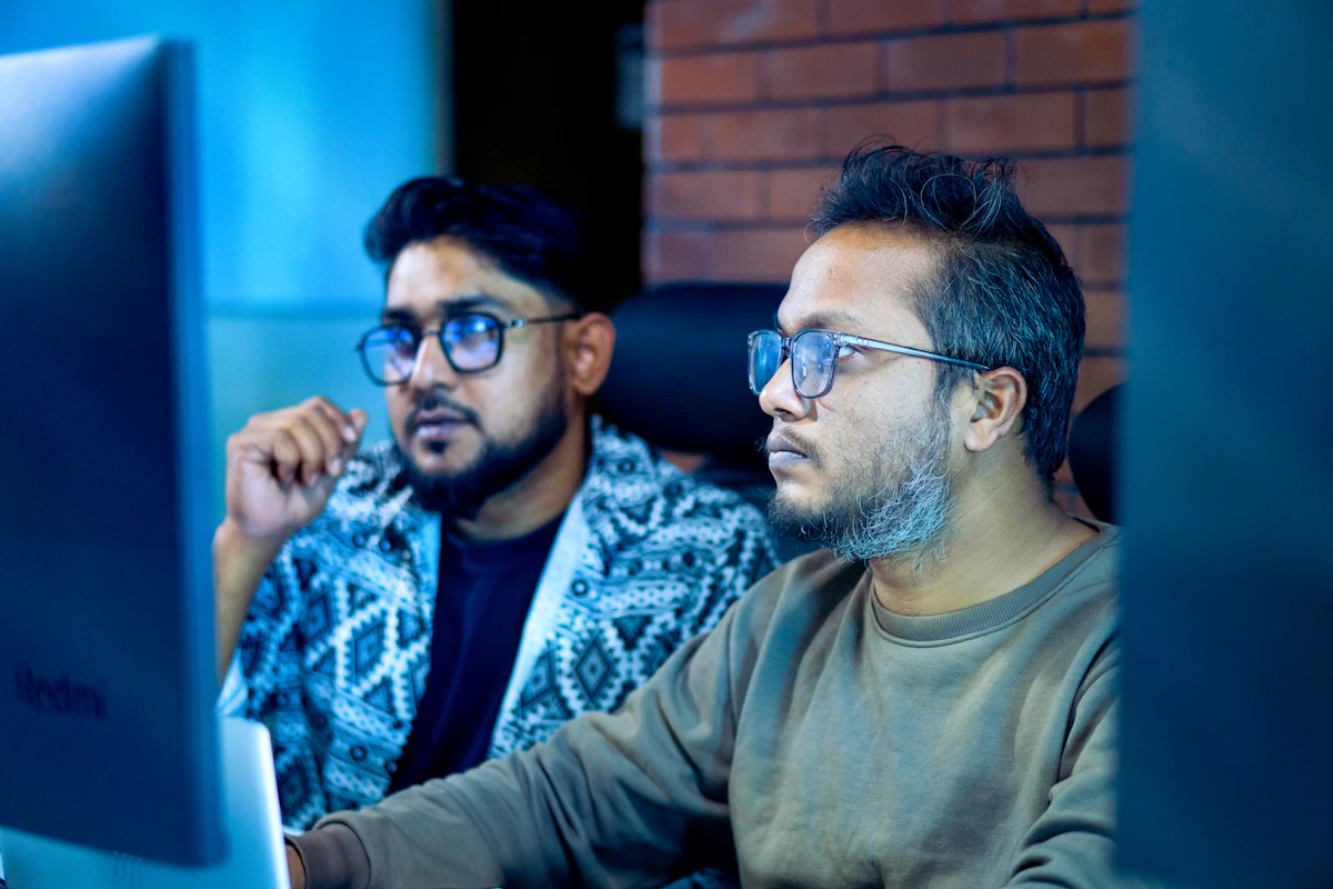 Two colleagues studying something on a screen with close attention