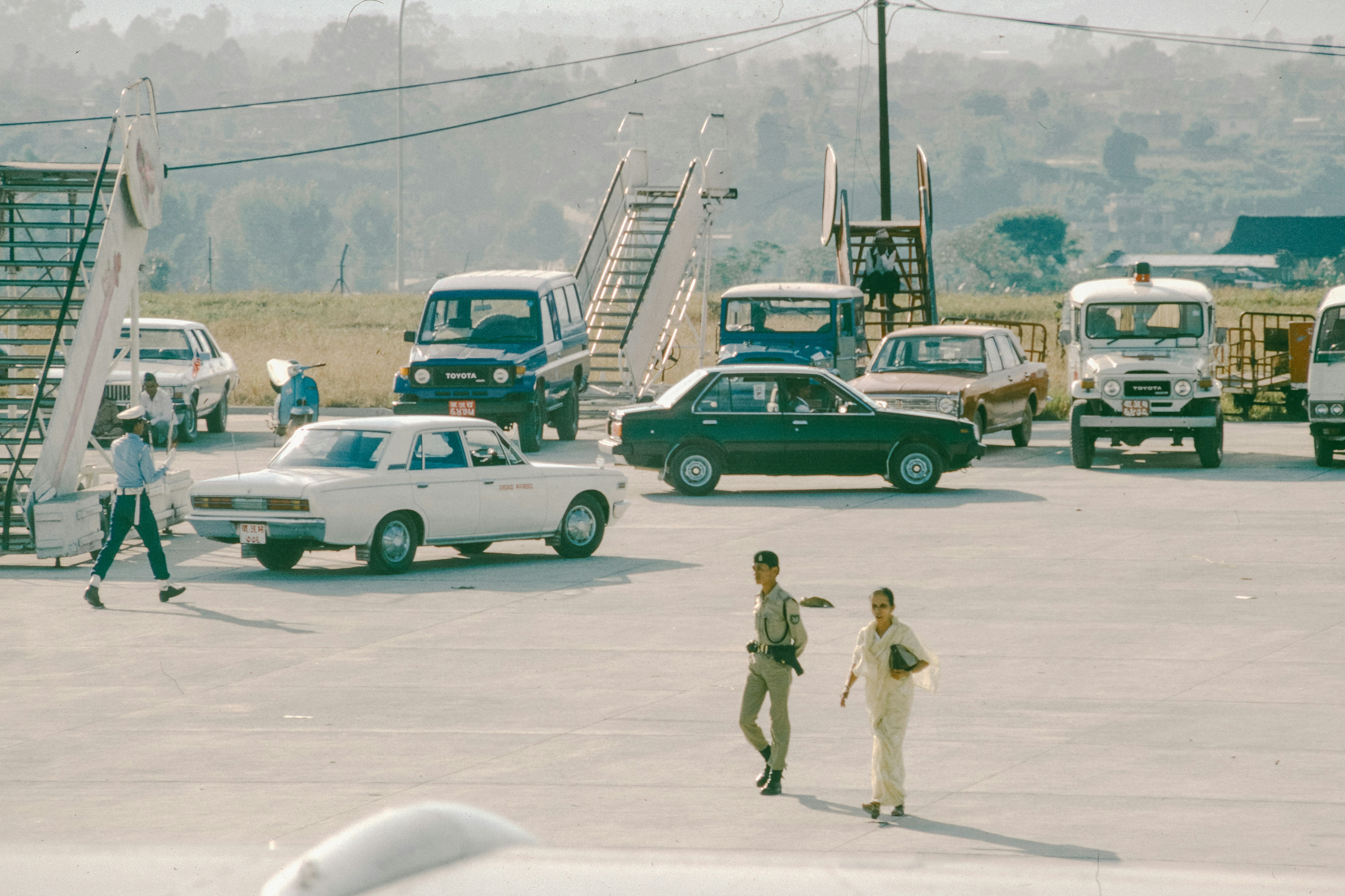 Cars and people at an airport tarmac