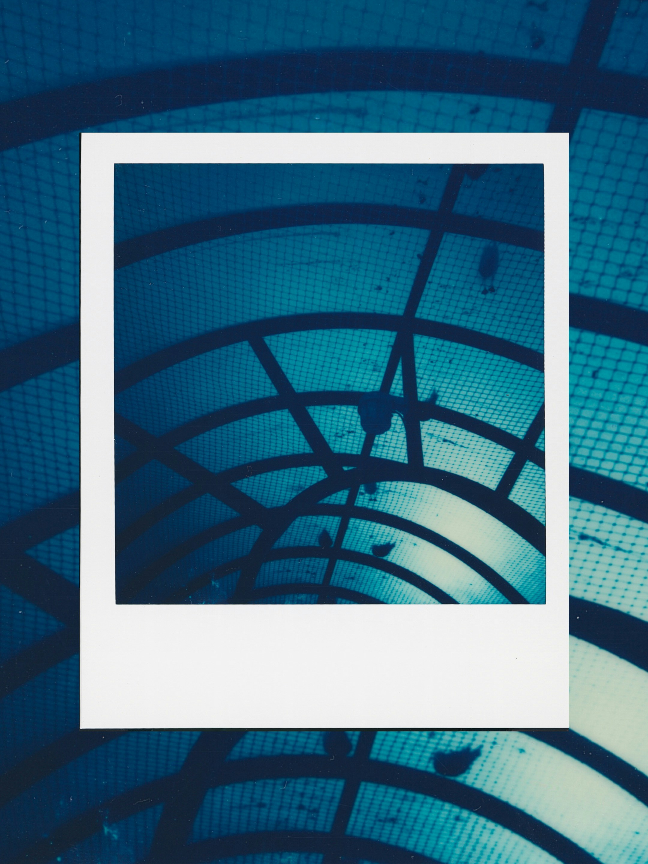 Abstract blue geometric pattern inside a polaroid frame.