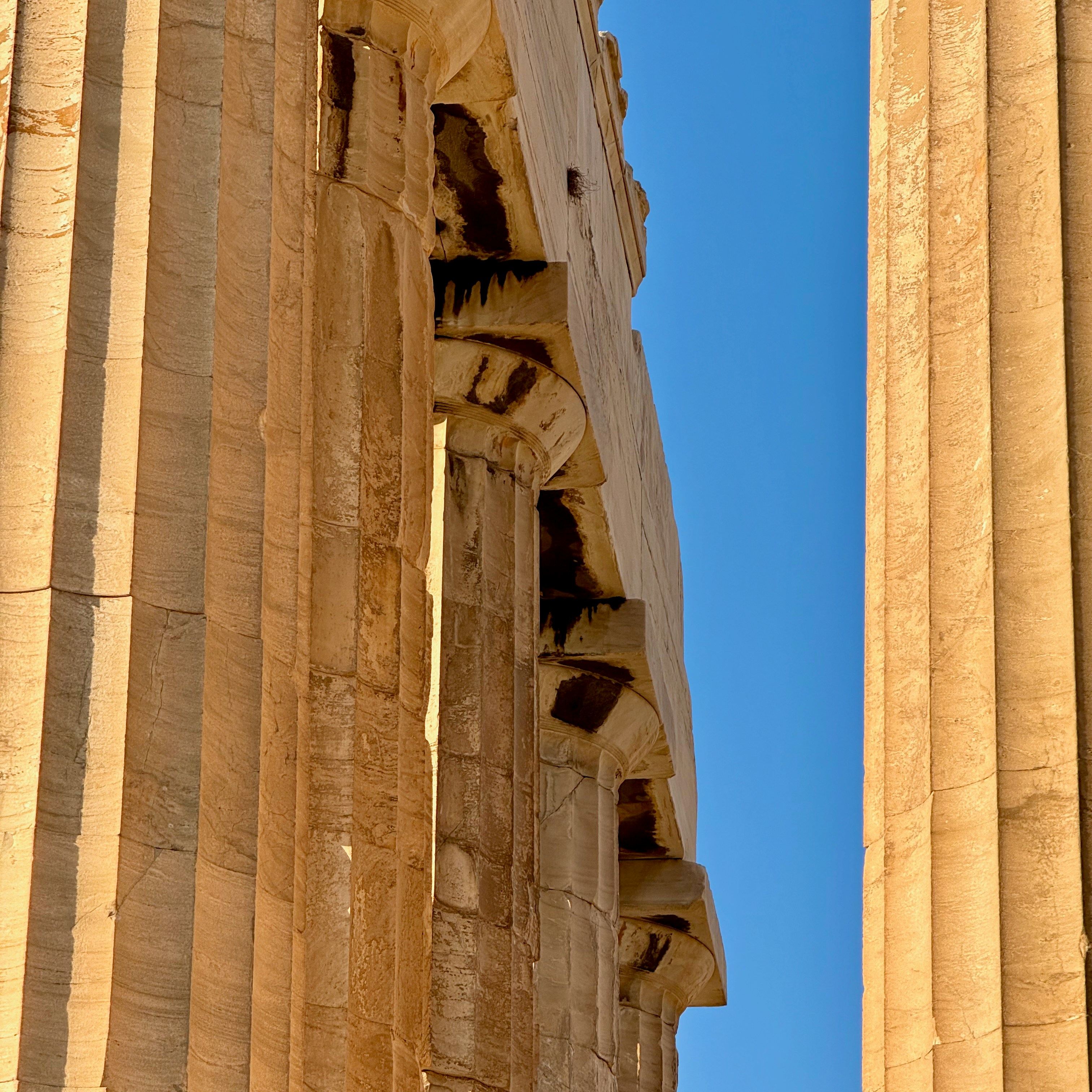 Ancient greek columns against a clear blue sky