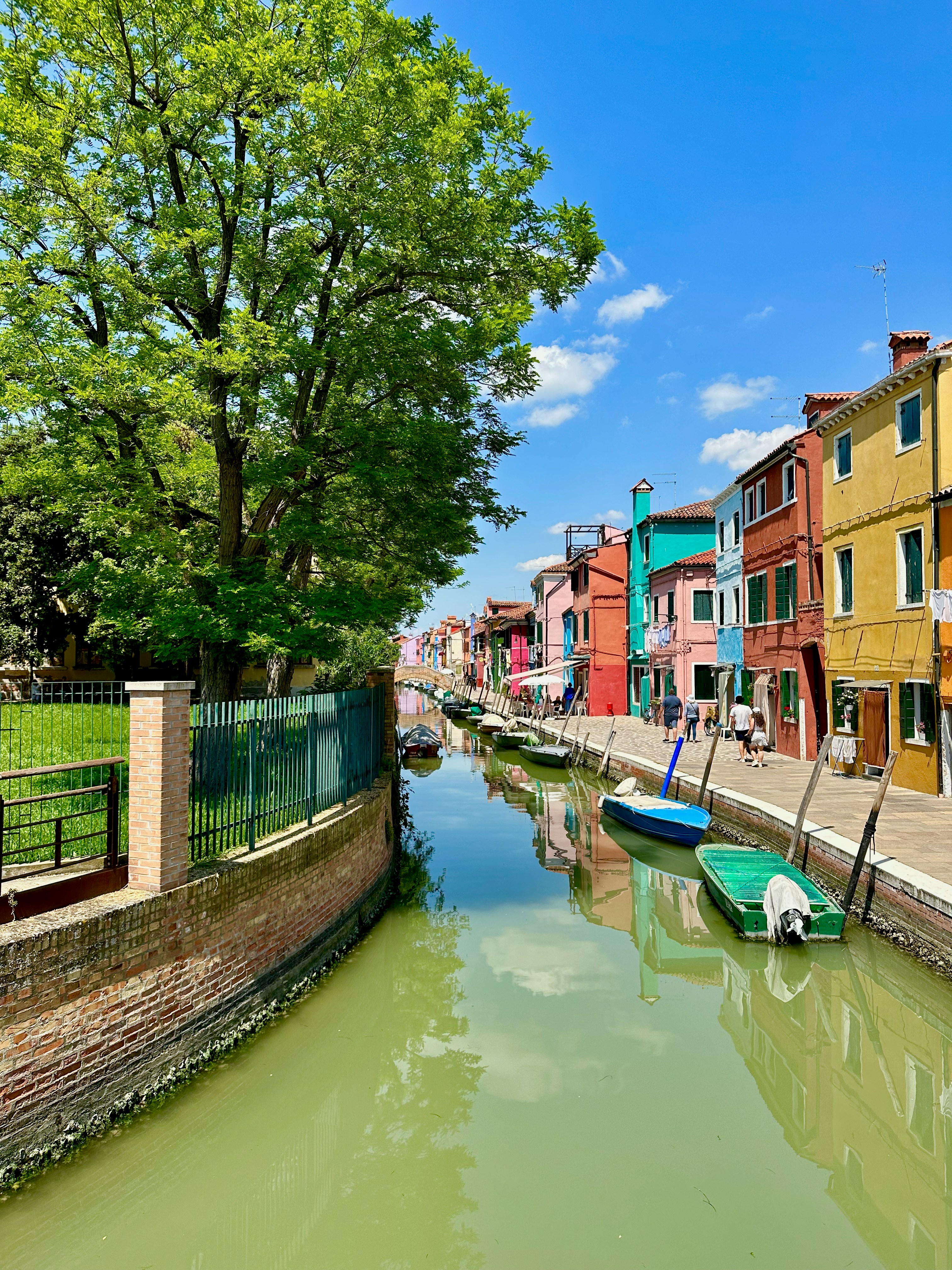 Colorful buildings line canal with boats on sunny day