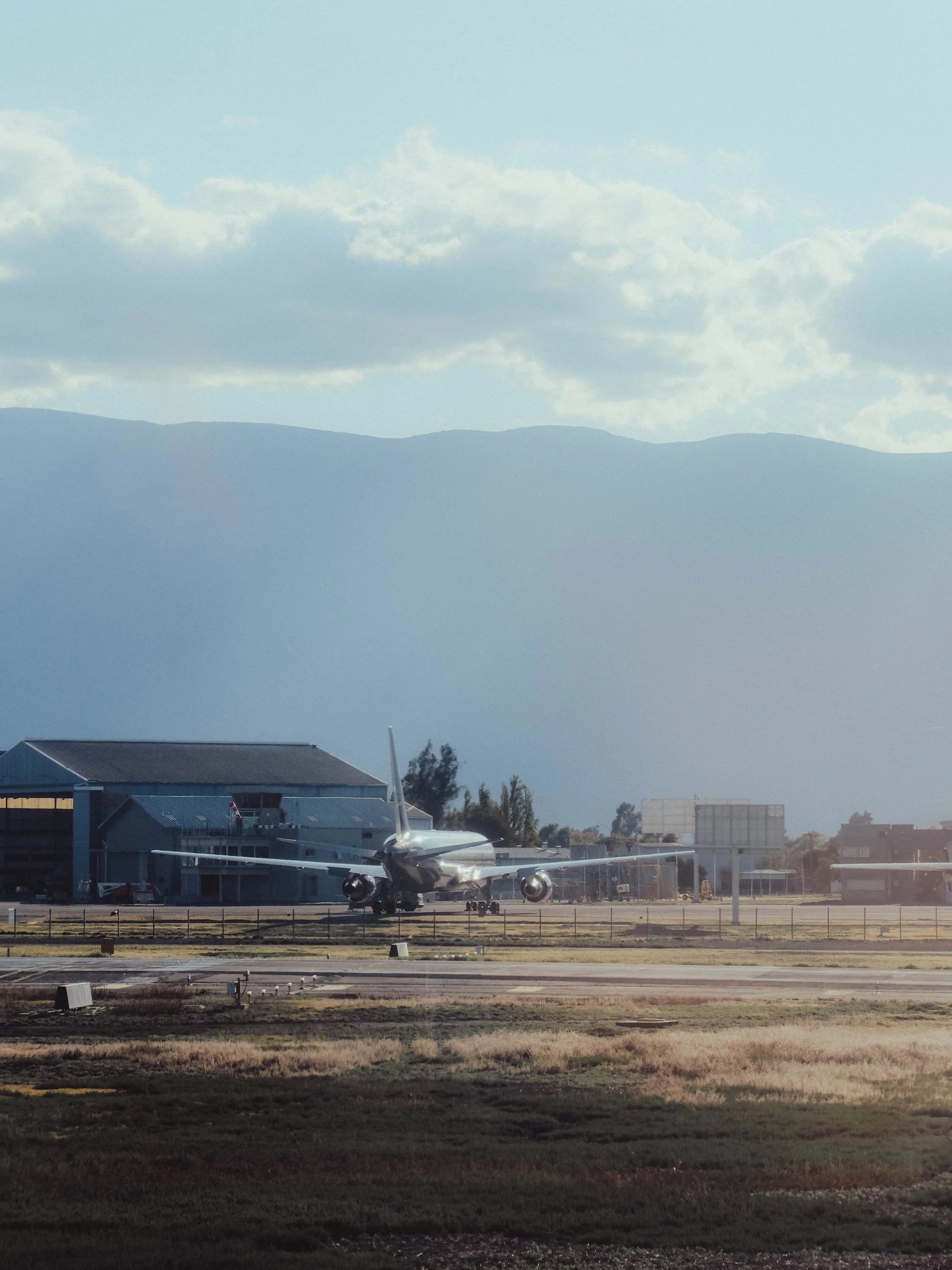 Light aircraft on the apron near a hangar at dusk