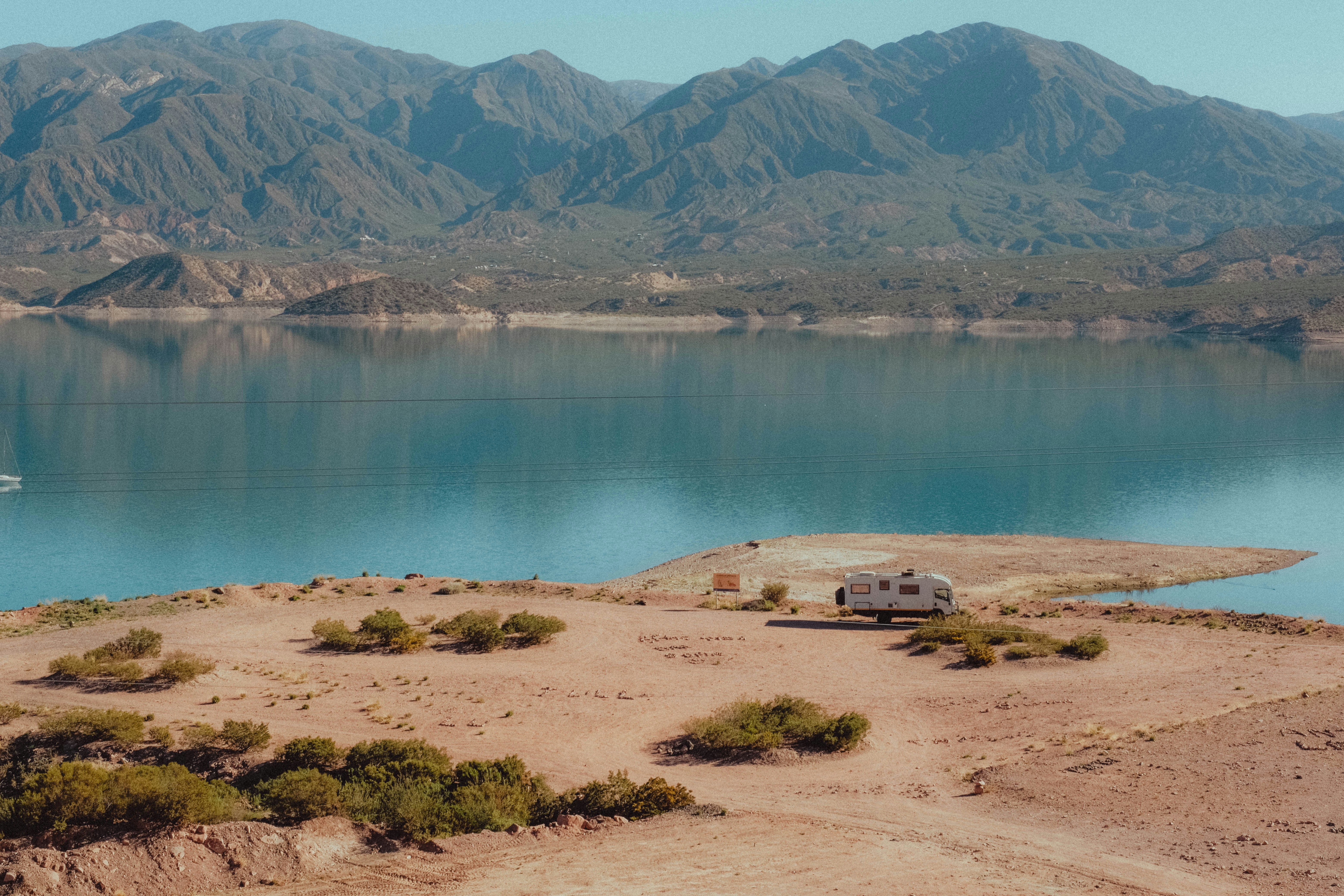 Rv parked on a dry lakebed with mountains behind