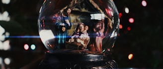Nativity scene inside a snow globe with bokeh lights.