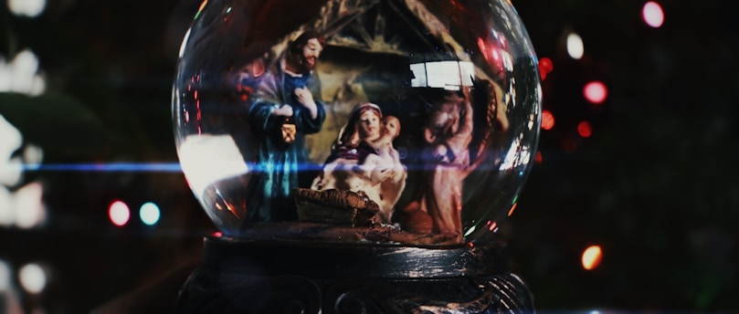 Nativity scene inside a snow globe with bokeh lights.