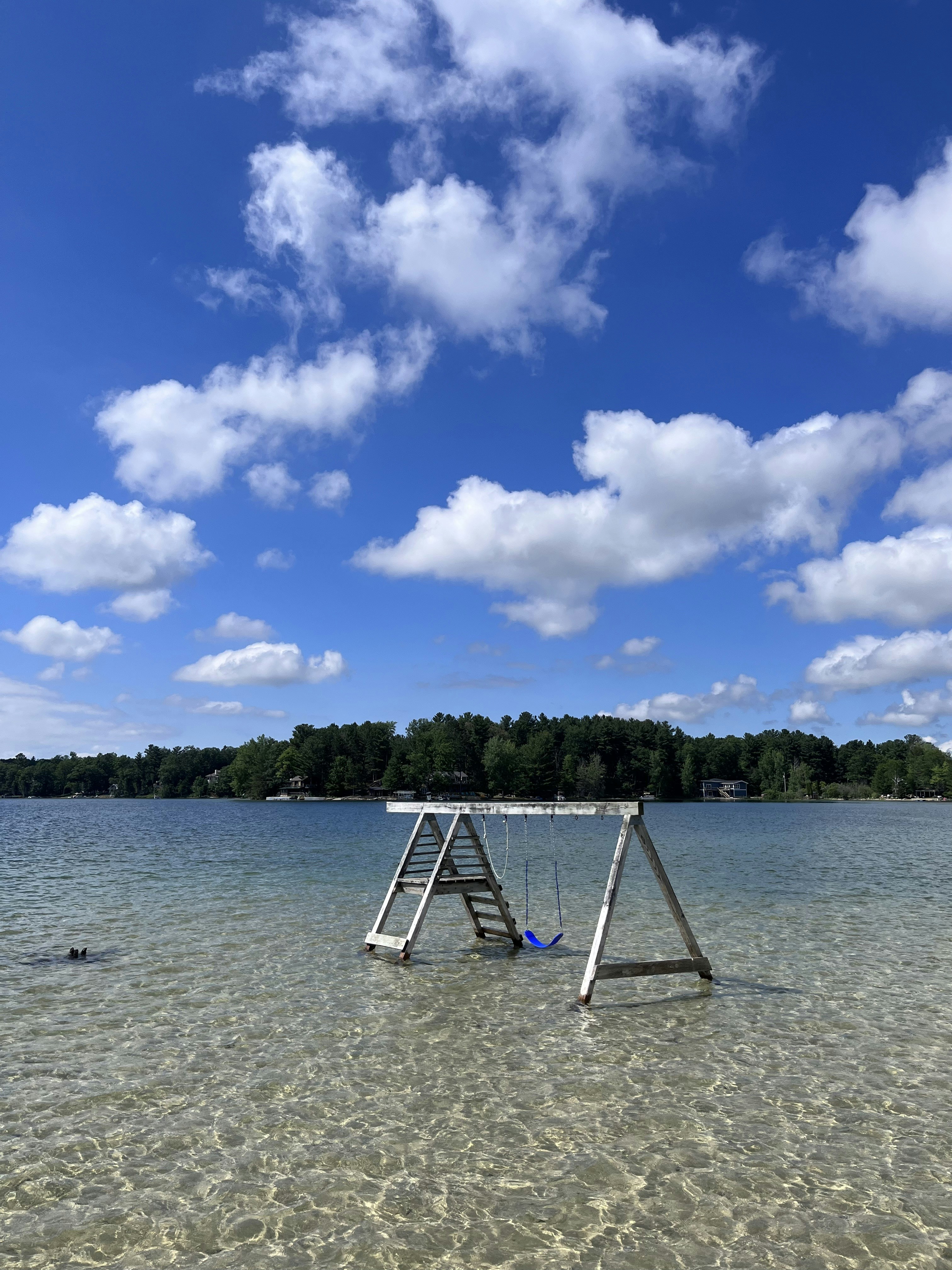 Swing set partially submerged in clear lake water