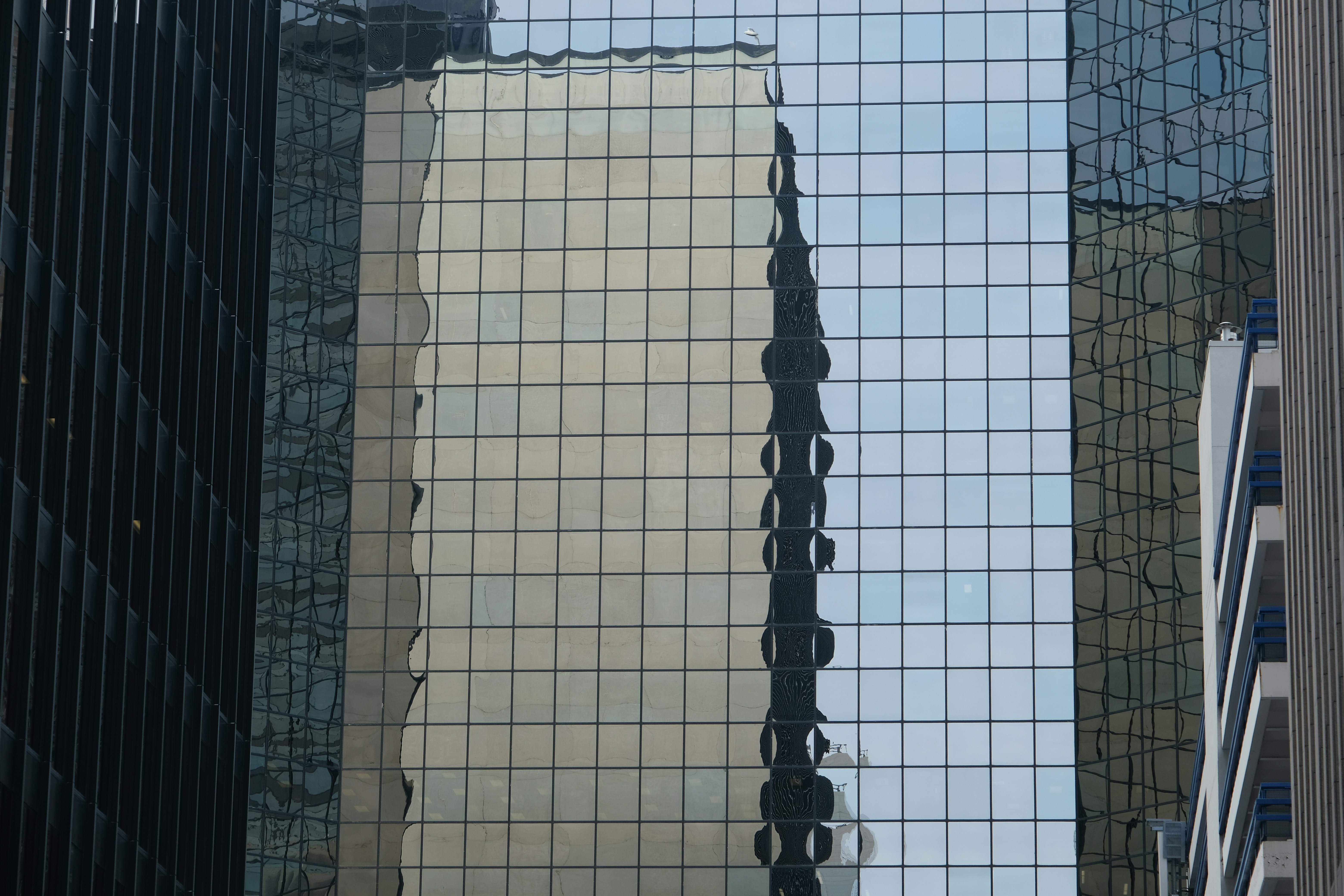 Modern glass buildings reflecting city lights at night.