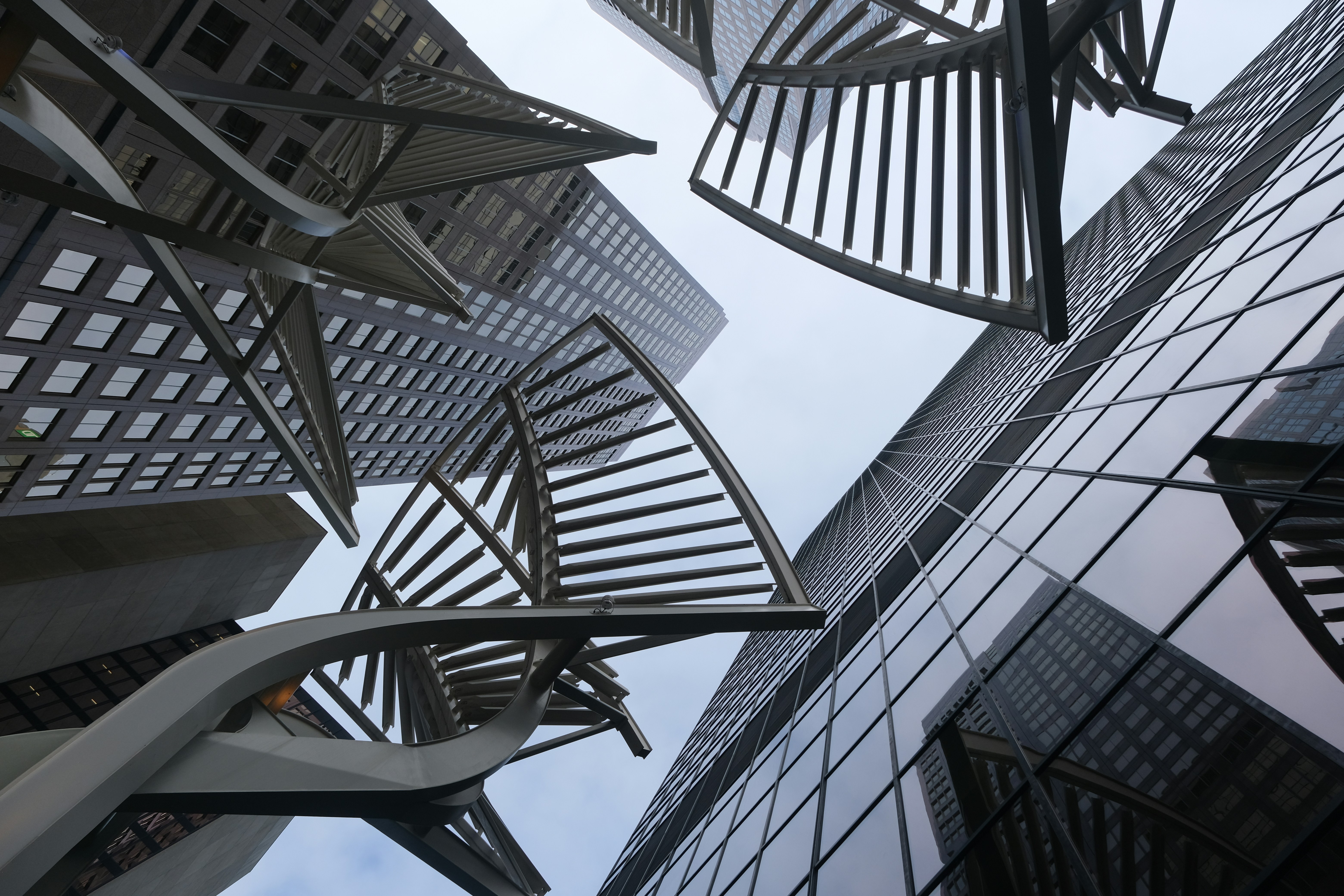 Modern skyscrapers and abstract sculpture against cloudy sky
