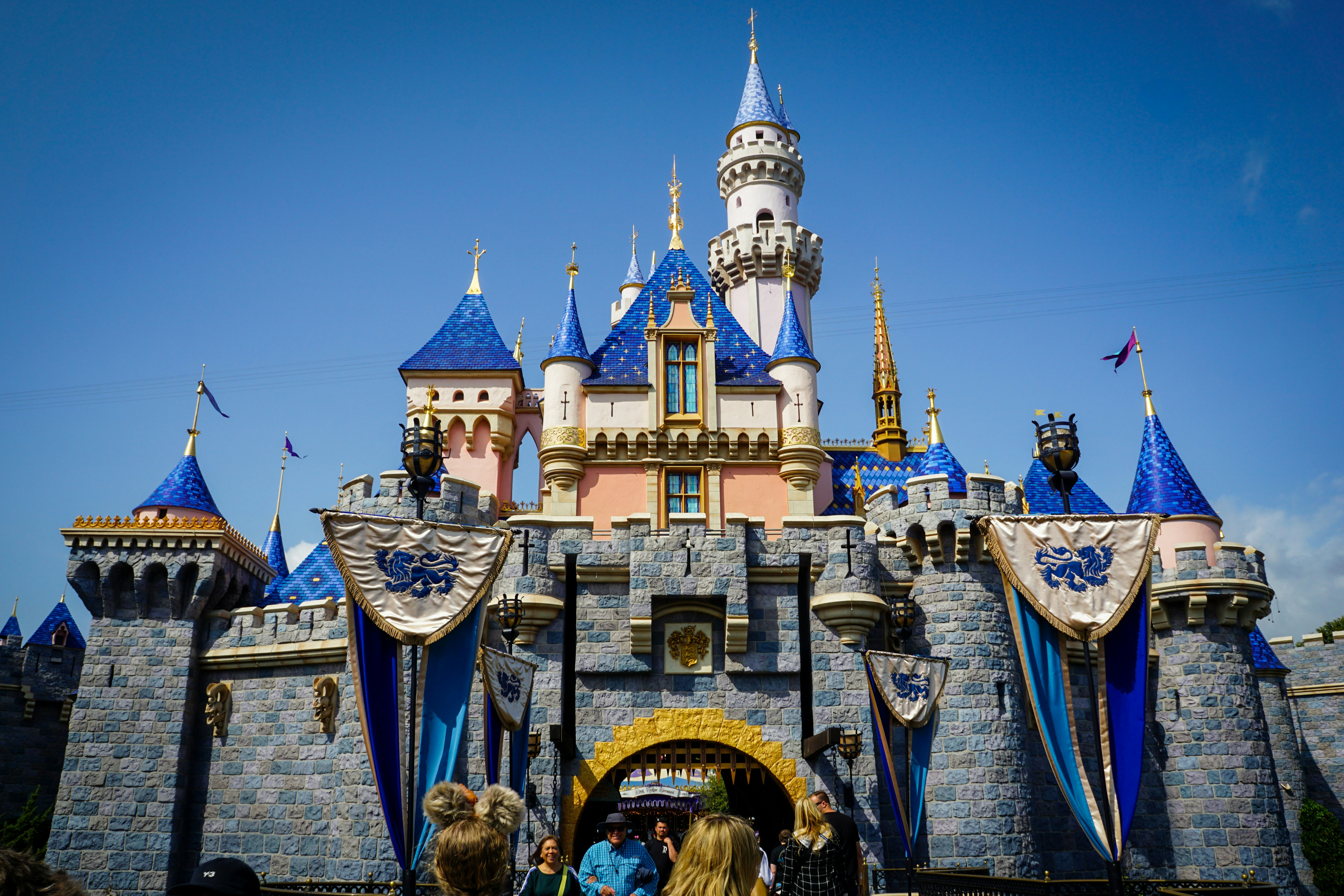 Ein Märchenschloss mit blauen Türmen unter klarem Himmel.