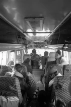 Passengers inside a bus looking out windows.