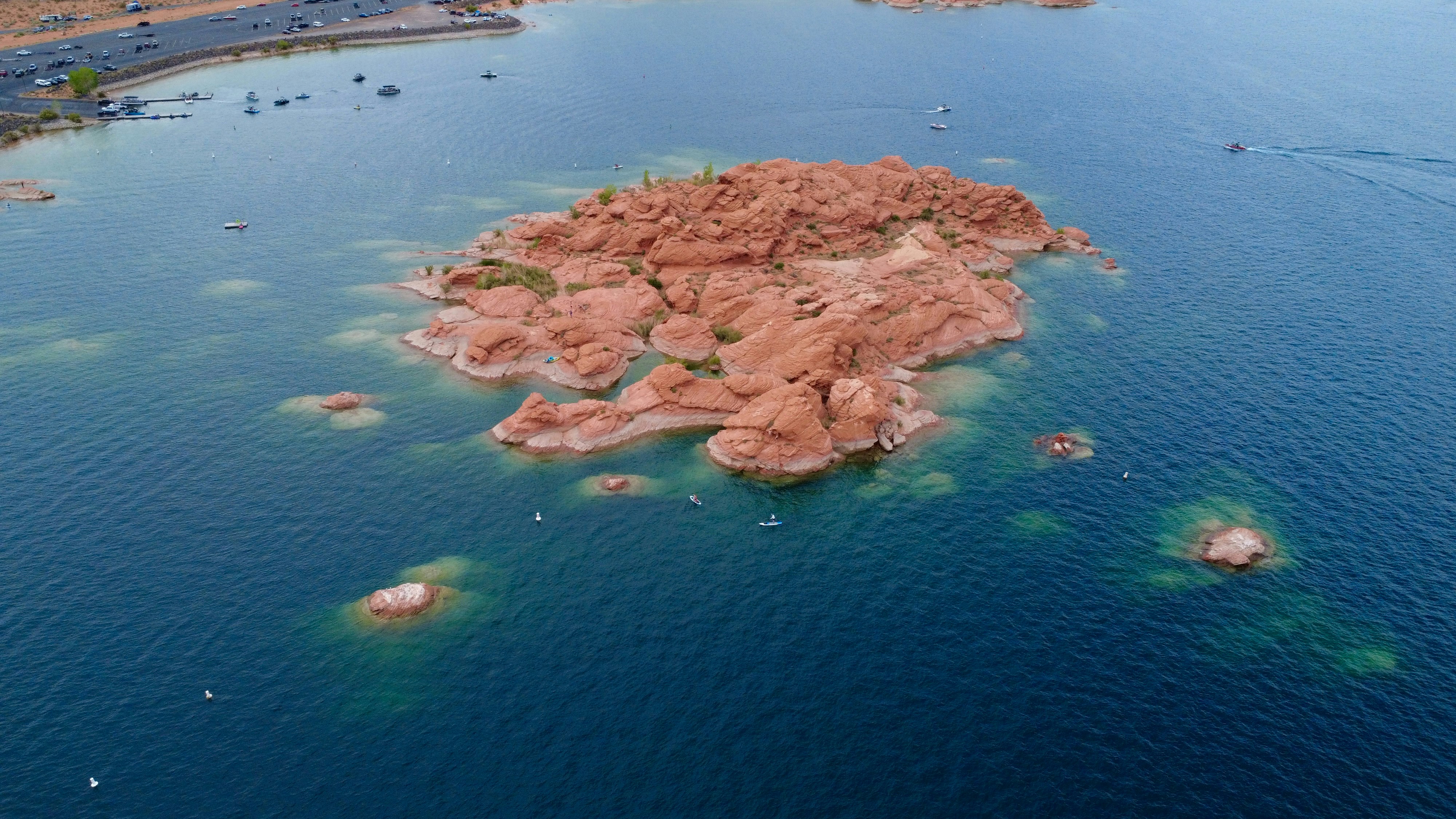 Red rock island formation in deep blue water photo – Free Lake Image on ...