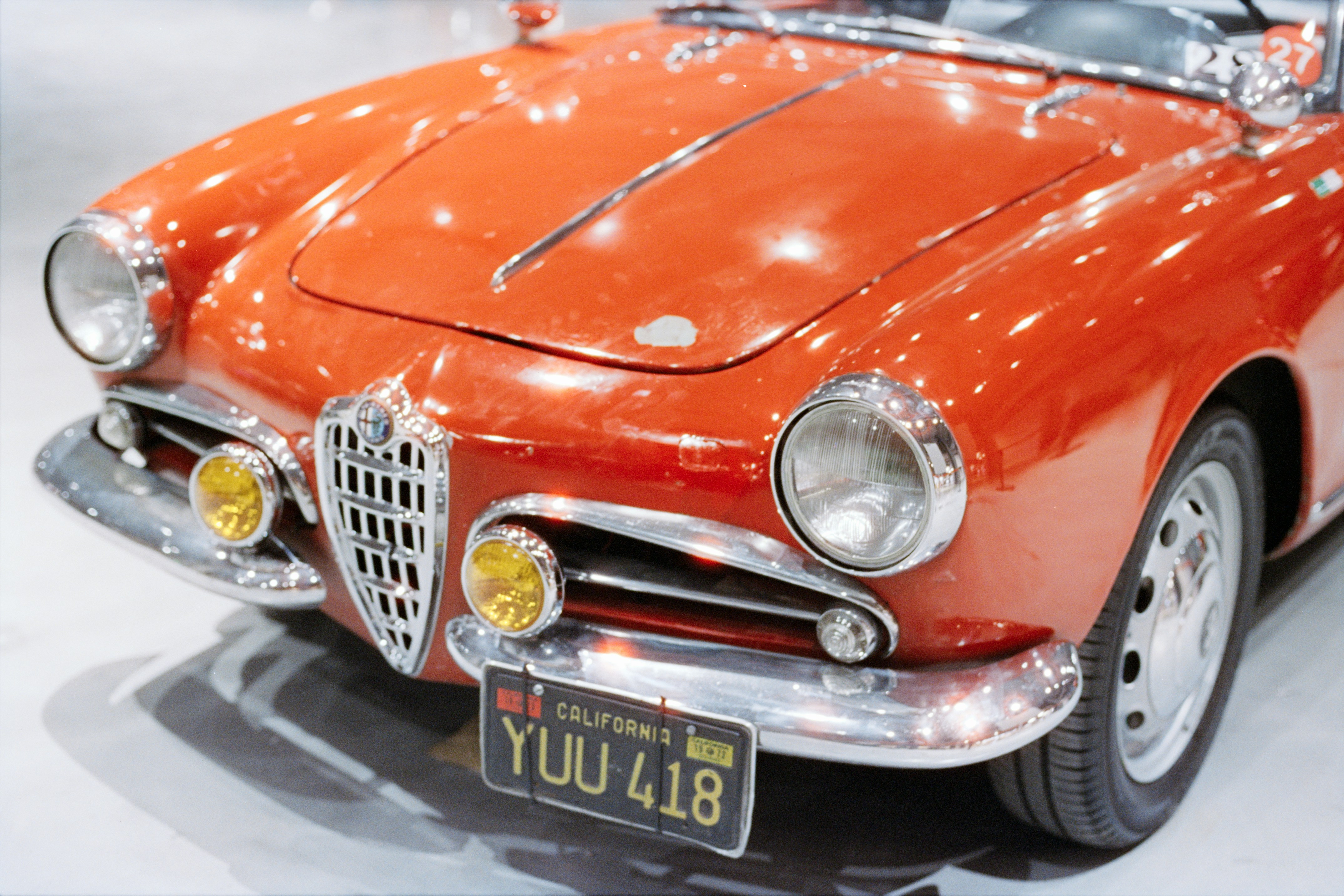 Close-up of a vintage red car's front grille.