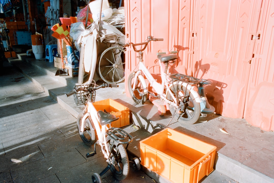 Two bicycles with orange crates parked near wall