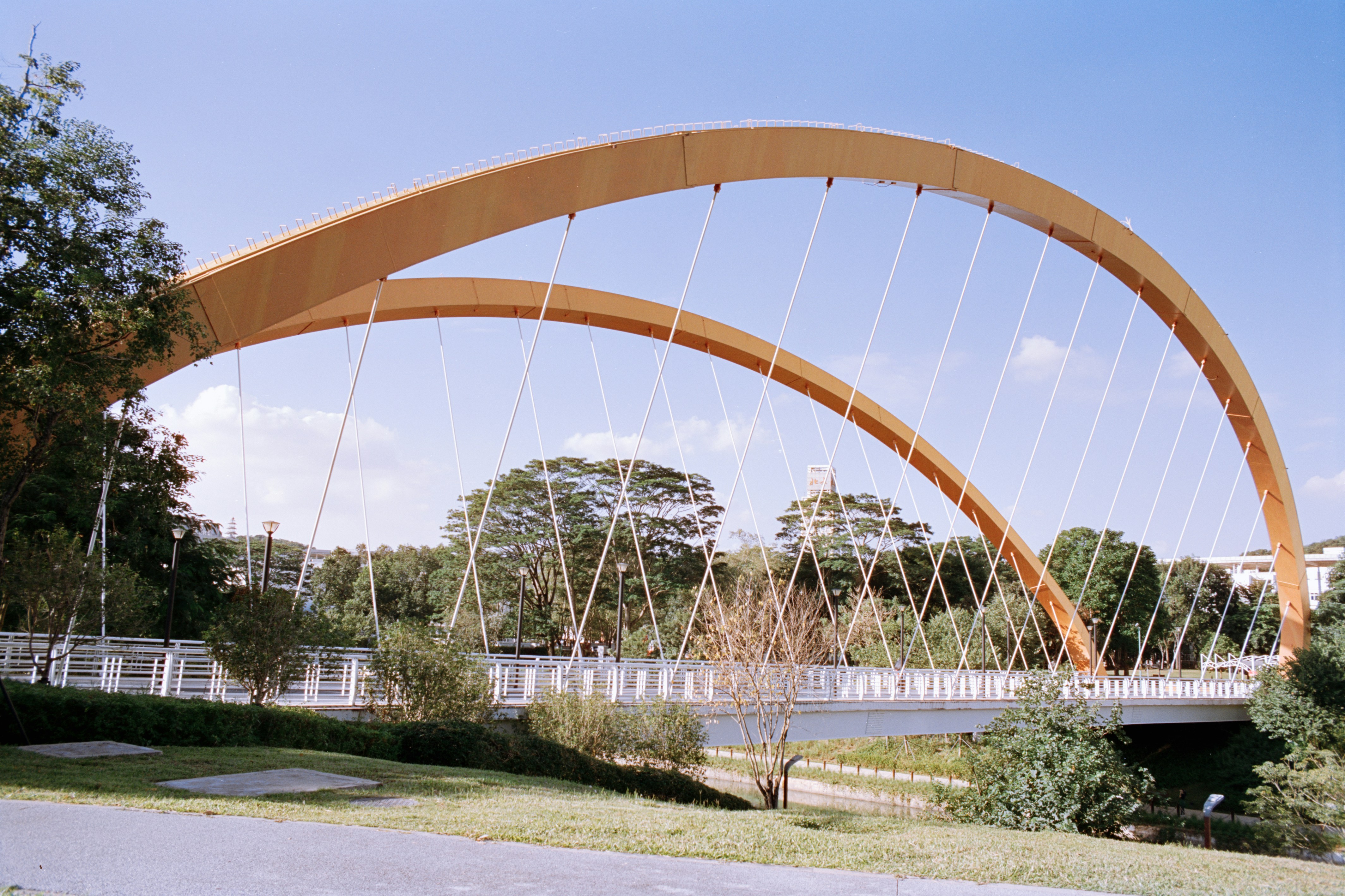 Modern orange arch bridge over a river